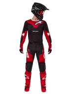 Alpinestars 2025 Racer Veil Gear Set, zestaw motocrossowy w kolorze czerwonym i czarnym, koszulka z białym logo, pasujące spodnie z czerwonymi panelami, jaskrawoczerwone buty, czarny kask z pomarańczowymi goglami i czerwone rękawice, wysokowydajny strój do wyścigów terenowych
