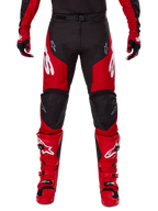Zestaw Alpinestars 2025 Racer Veil, spodnie i buty motocrossowe, czerwono-czarne, wyraźne białe logo na udach i butach, noszone z dopasowanymi rękawicami, wytrzymała konstrukcja tekstylna ze skórzanymi wzmocnieniami do wyścigów off-road