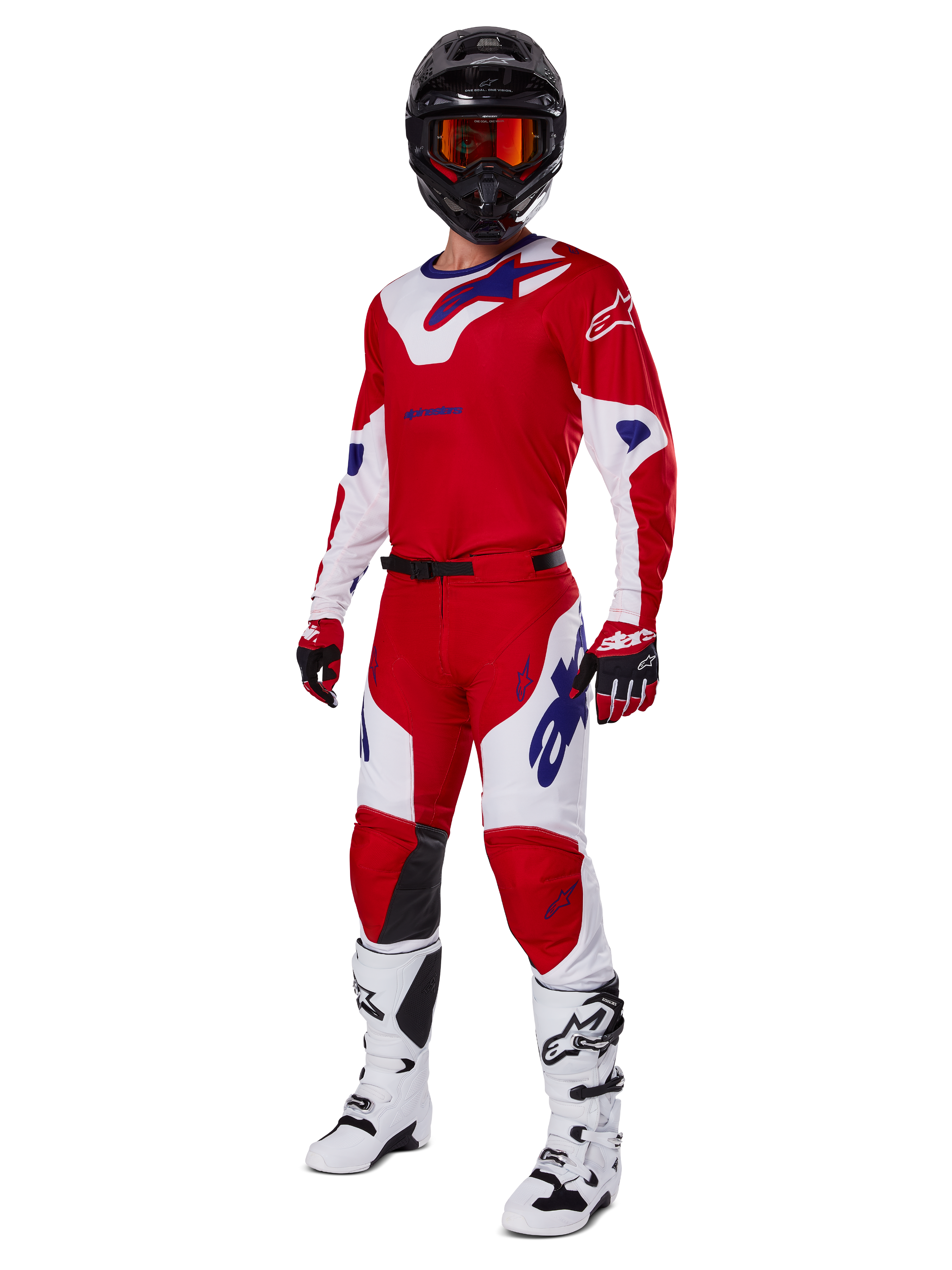 Spodnie Alpinestars Racer Veil 2025, spodnie motocrossowe, jaskrawoczerwone i białe, prezentowane jako część pełnego zestawu wyścigowego z dopasowaną koszulką, czarnym kaskiem z pomarańczowymi goglami, białymi butami i czerwonymi rękawicami, z wyraźnym niebieskim logo Alpinestars.