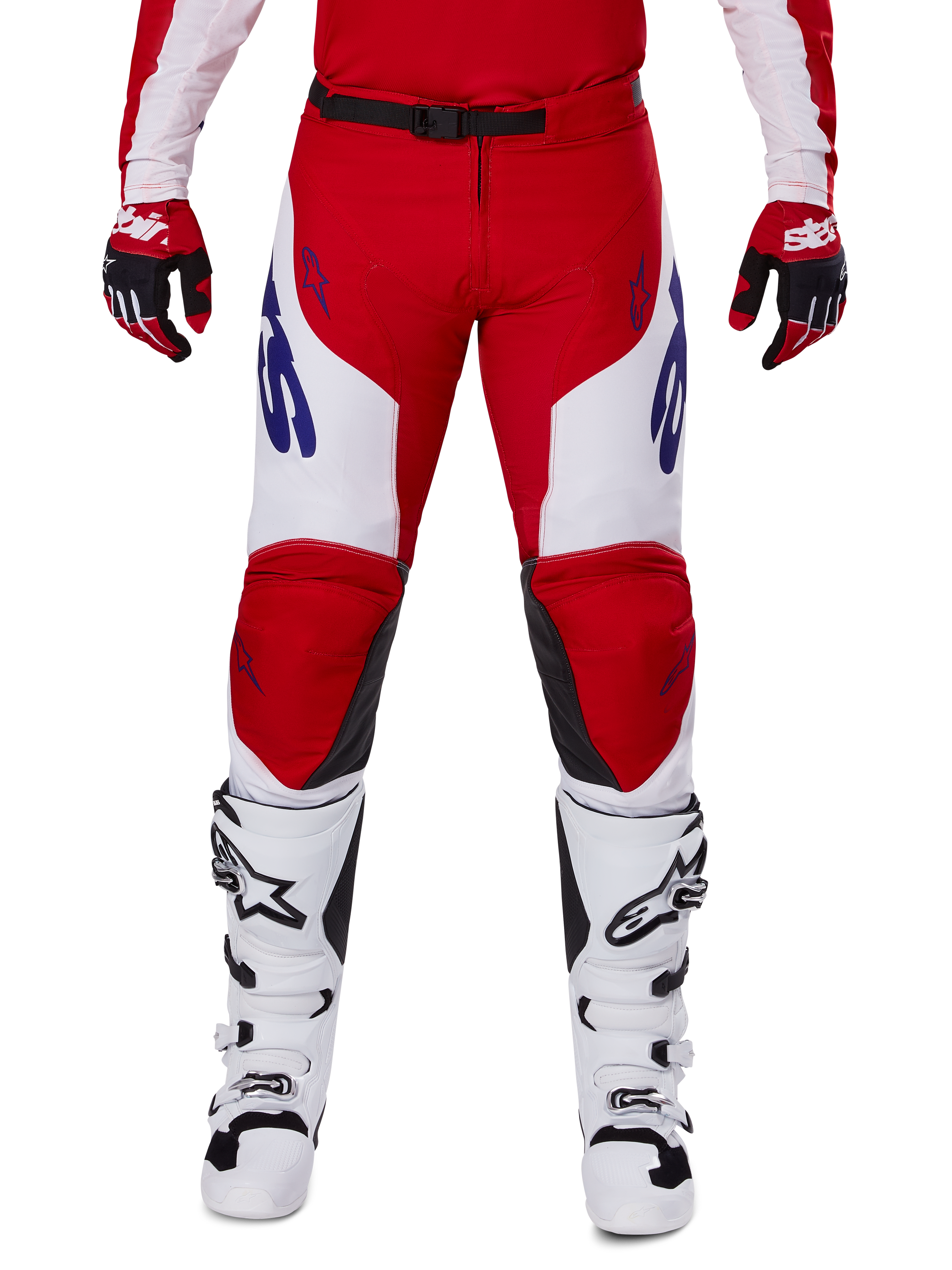 Alpinestars 2025 Racer Veil Pants, spodnie motocrossowe, jaskrawoczerwone i białe, zestawione z czerwonymi rękawicami i białymi butami, niebieskie logo na udach, czarny pas w talii, ergonomiczny sportowy krój