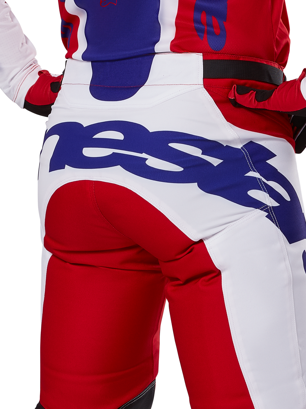 Alpinestars Racer Veil Pants 2025, spodnie motocrossowe, jaskrawoczerwone i białe z niebieskim brandingiem, widok z tyłu na detal siedziska z dużym logo Alpinestars, element dopasowanego stroju wyścigowego off-road