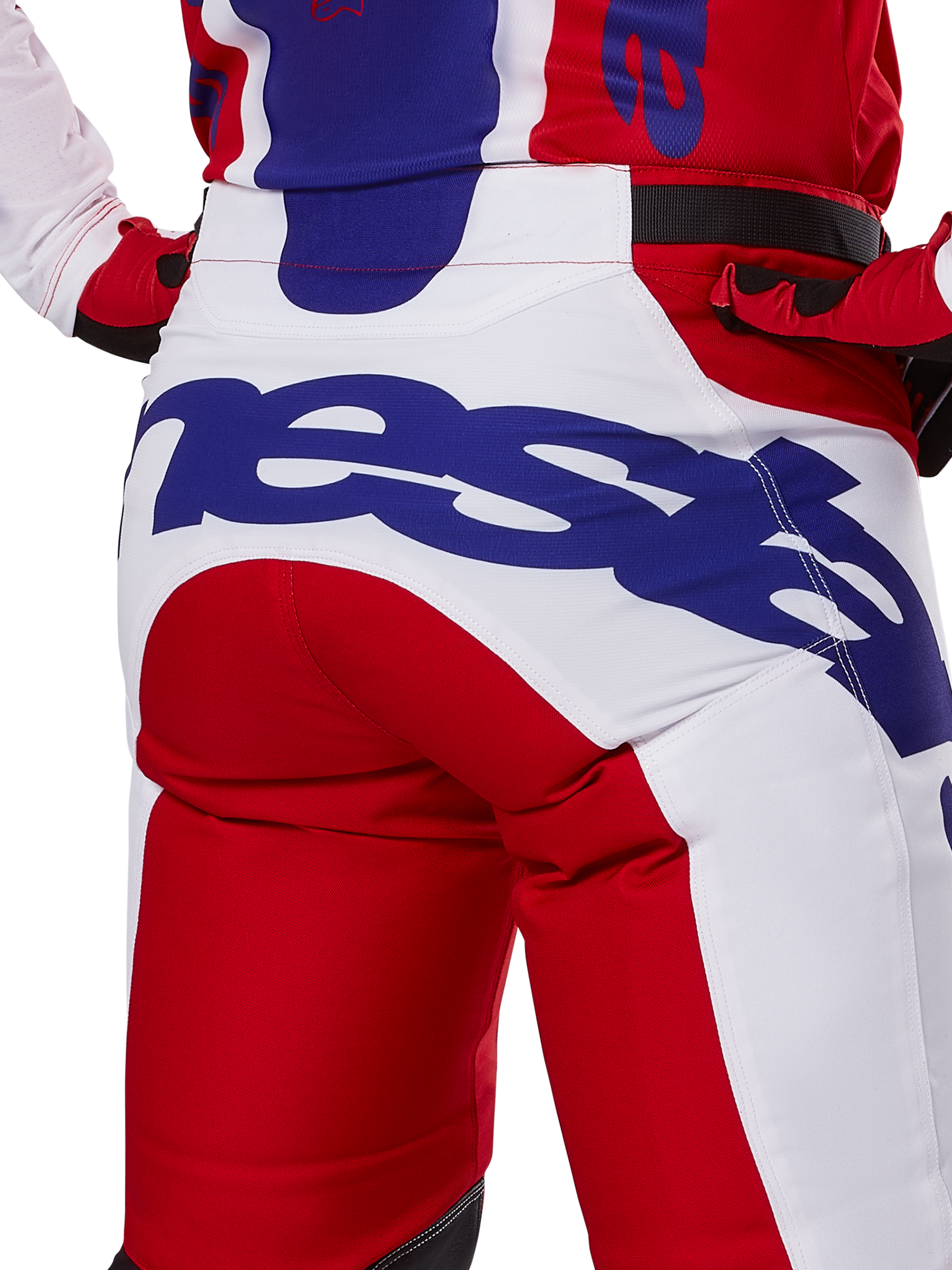 Alpinestars Racer Veil Pants 2025, spodnie motocrossowe, jaskrawoczerwone i białe z niebieskim brandingiem, widok z tyłu na detal siedziska z dużym logo Alpinestars, element dopasowanego stroju wyścigowego off-road