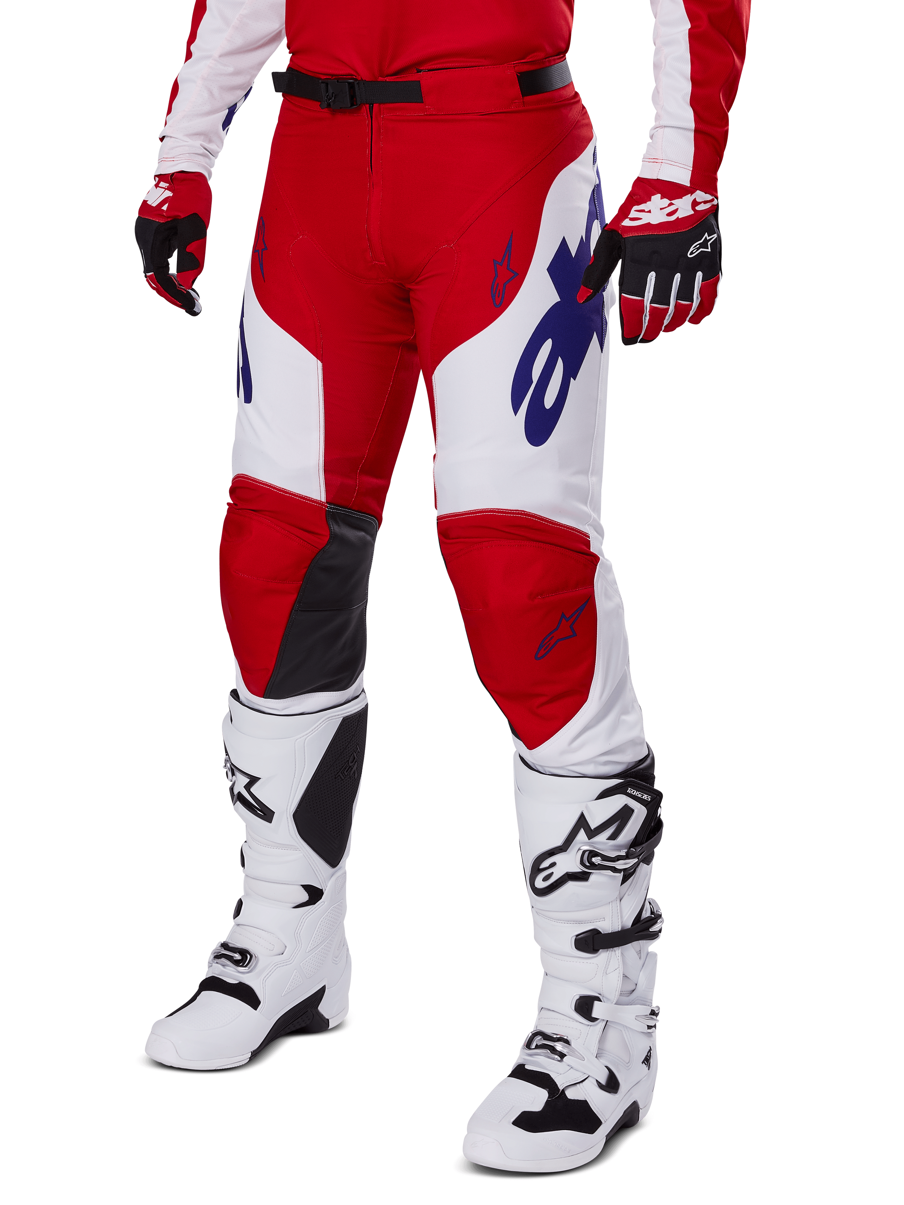 Spodnie Alpinestars Racer Veil 2025, spodnie motocrossowe, intensywnie czerwone i białe, z niebieskimi logo Alpinestars i czarnymi skórzanymi panelami na kolanach, zestawione z czerwonymi rękawicami i białymi butami motocrossowymi, skoordynowany komplet odzieży do wyścigów terenowych