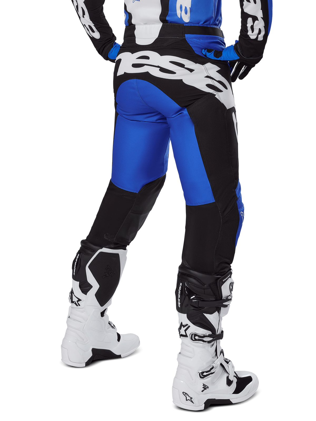 Alpinestars 2025 Racer Veil Pants, spodnie motocrossowe, niebieskie i czarne, widok z tyłu przedstawiający duże białe logo na siedzeniu, noszone z pasującą bluzą i białymi butami, wytrzymały materiał techniczny do jazdy terenowej