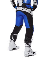 Alpinestars 2025 Racer Veil Pants, spodnie motocrossowe, niebieskie i czarne, widok z tyłu przedstawiający duże białe logo na siedzeniu, noszone z pasującą bluzą i białymi butami, wytrzymały materiał techniczny do jazdy terenowej