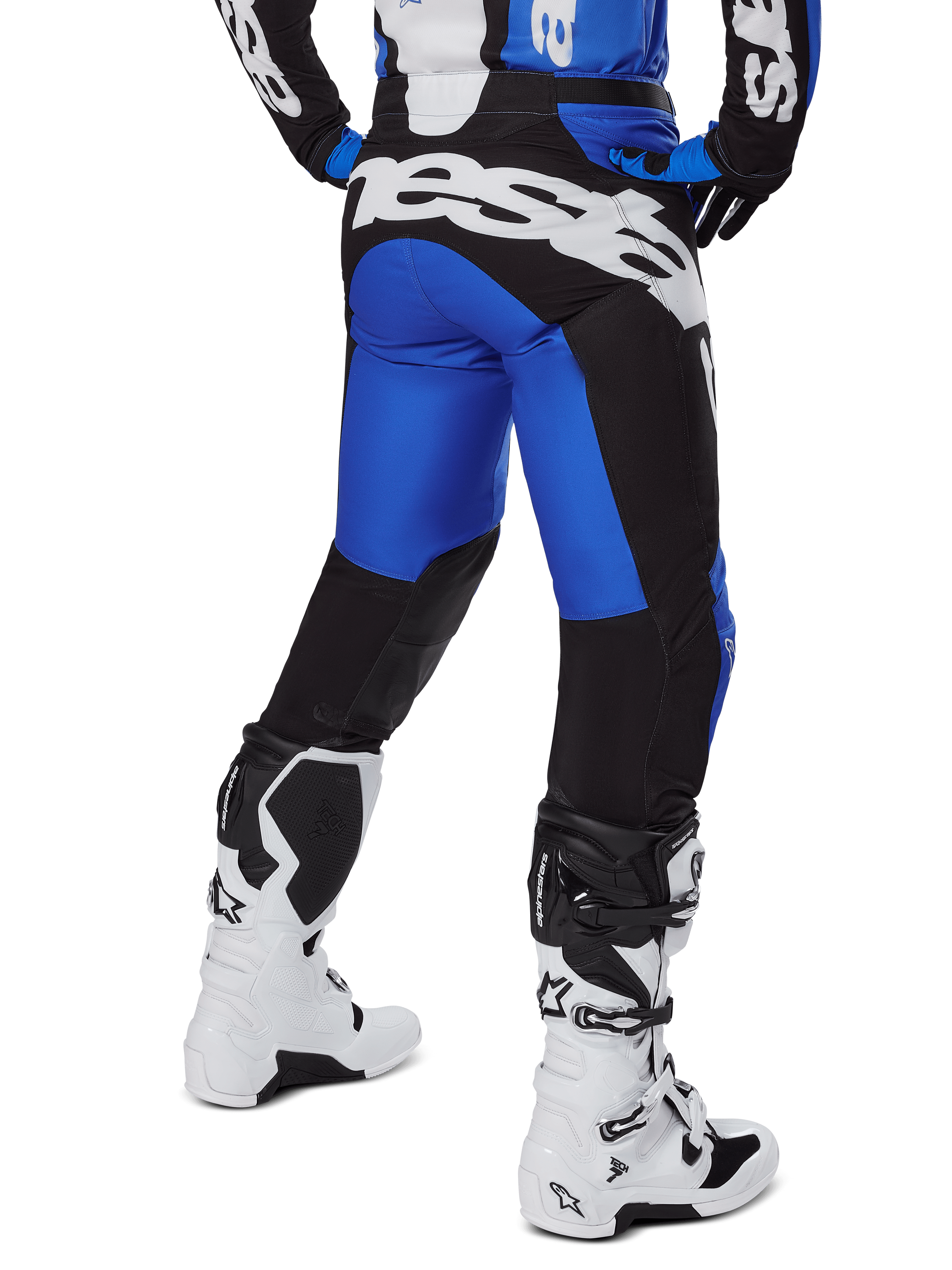 Alpinestars 2025 Racer Veil Pants, spodnie motocrossowe, niebieskie i czarne, widok z tyłu przedstawiający duże białe logo na siedzeniu, noszone z pasującą bluzą i białymi butami, wytrzymały materiał techniczny do jazdy terenowej