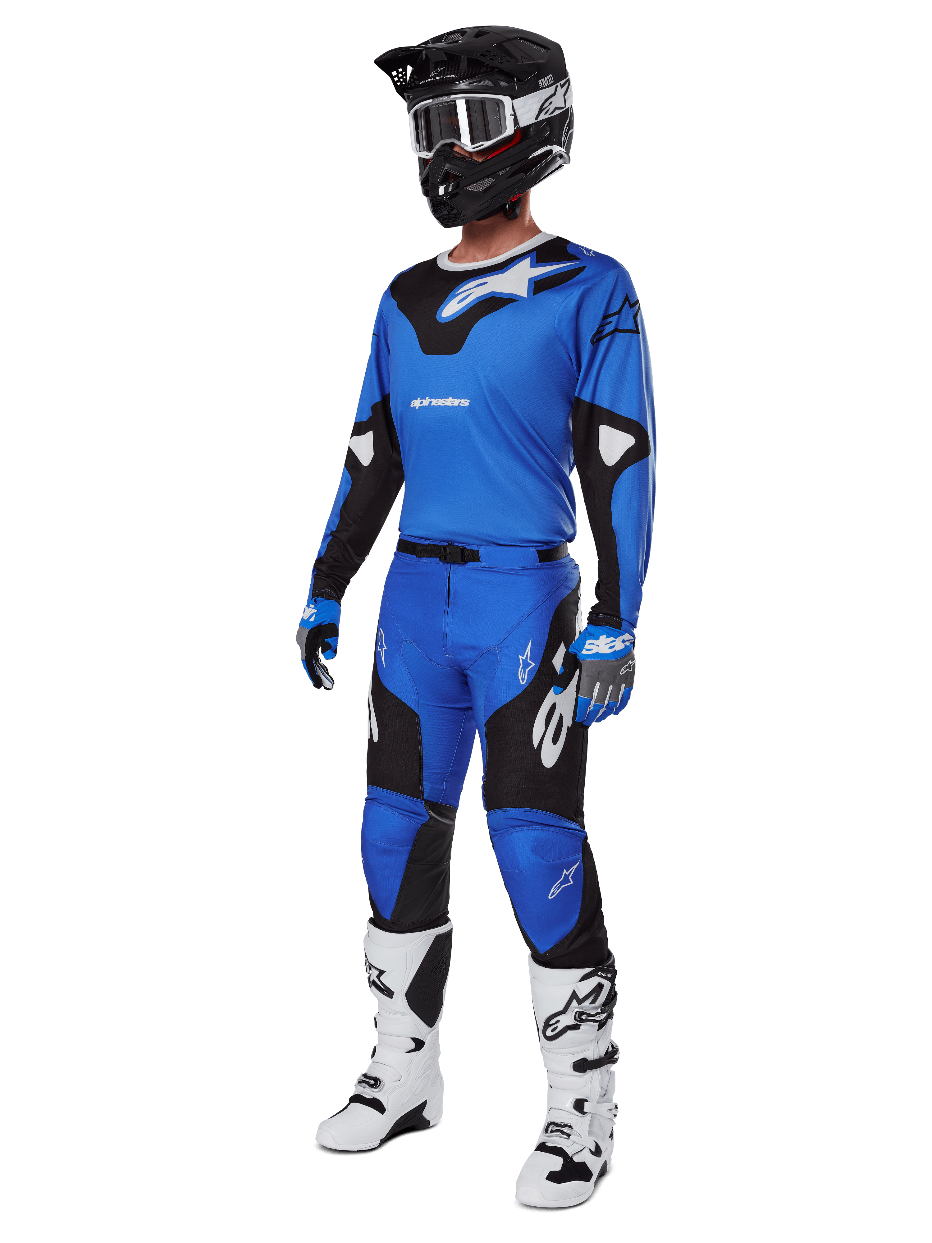 Zawodnik motocrossowy w kompletnym stroju wyścigowym, spodnie Alpinestars 2025 Racer Veil w kolorze niebiesko-czarnym, dopasowana niebieska koszulka z białymi akcentami, czarny kask z białymi goglami, biało-czarne buty i niebieskie rękawice, spójny zestaw do jazdy terenowej