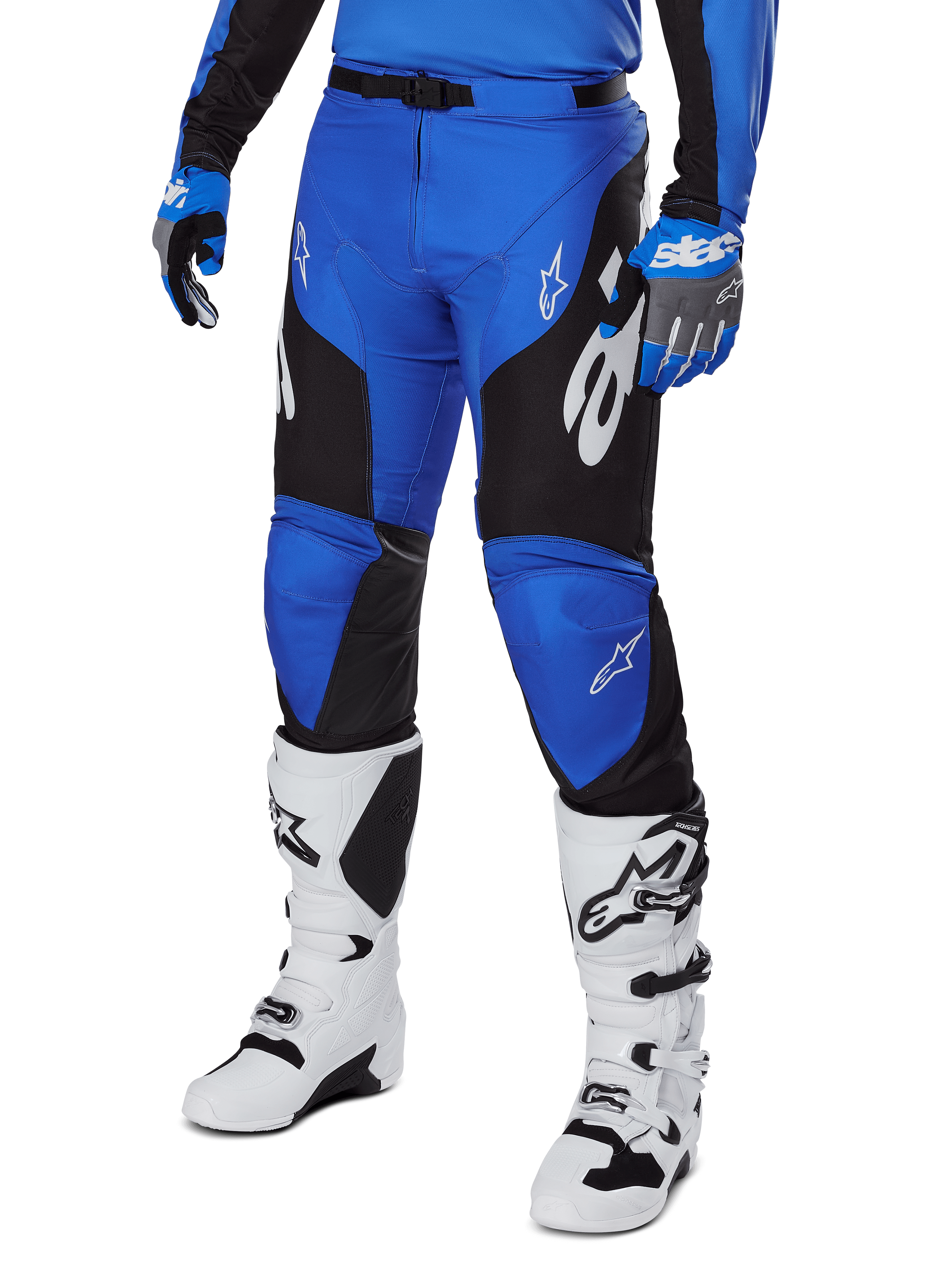Alpinestars Racer Veil Pants 2025, spodnie motocrossowe, niebiesko-czarne z białymi akcentami graficznymi, noszone z pasującą niebieską koszulką, rękawicami i białymi butami, wytrzymała odzież ochronna do wyścigów terenowych