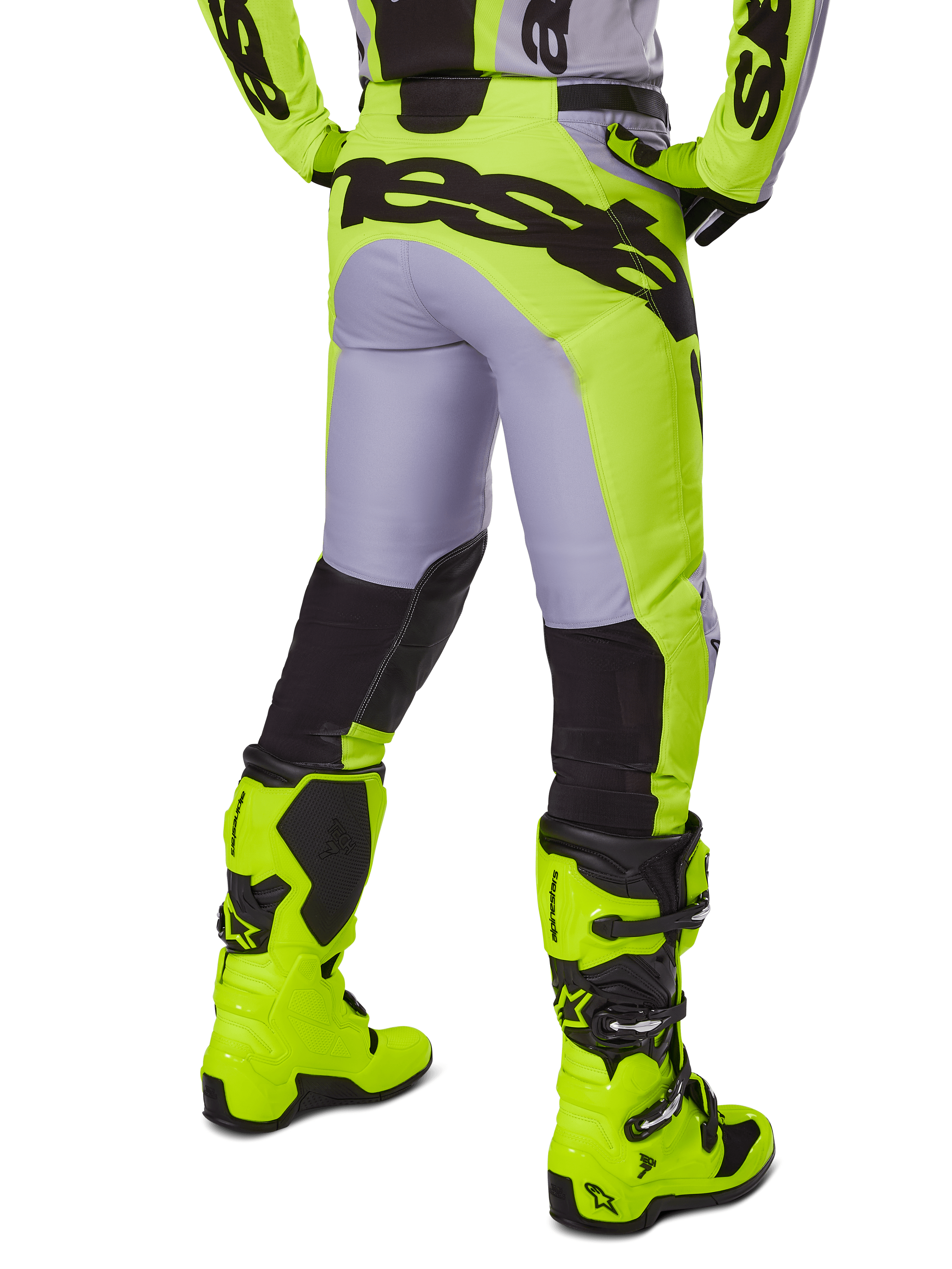 Alpinestars 2025 Racer Veil Pants, spodnie motocrossowe, szare i żółte neonowe, widok z tyłu przedstawiający ergonomiczną konstrukcję z dużym czarnym logo na siedzeniu, czarne panele na dole nogawek i pasujące jaskrawożółte buty wyścigowe
