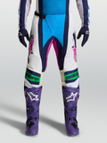Alpinestars Spodnie Techstar Maven, męskie spodnie motocrossowe w kolorze niebieskim i białym z różowymi akcentami, konstrukcja kolan Babel, widok z przodu na modelu.
