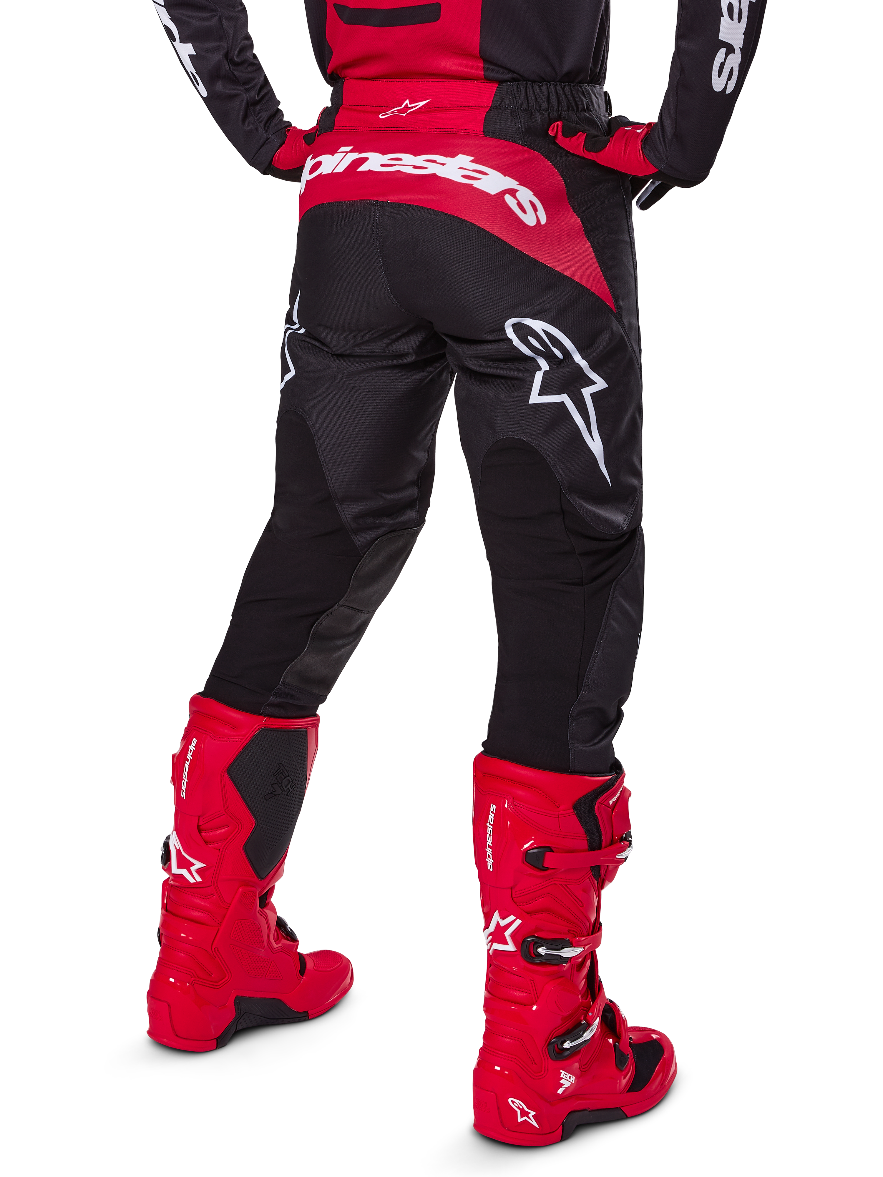 Alpinestars 2025 Fluid Haul Gear Set, widok z tyłu, czarno-czerwone spodnie motocrossowe z dużymi białymi logotypami, pasująca koszulka i intensywnie czerwone buty Tech 7, dopasowany zestaw wyścigowy off-road