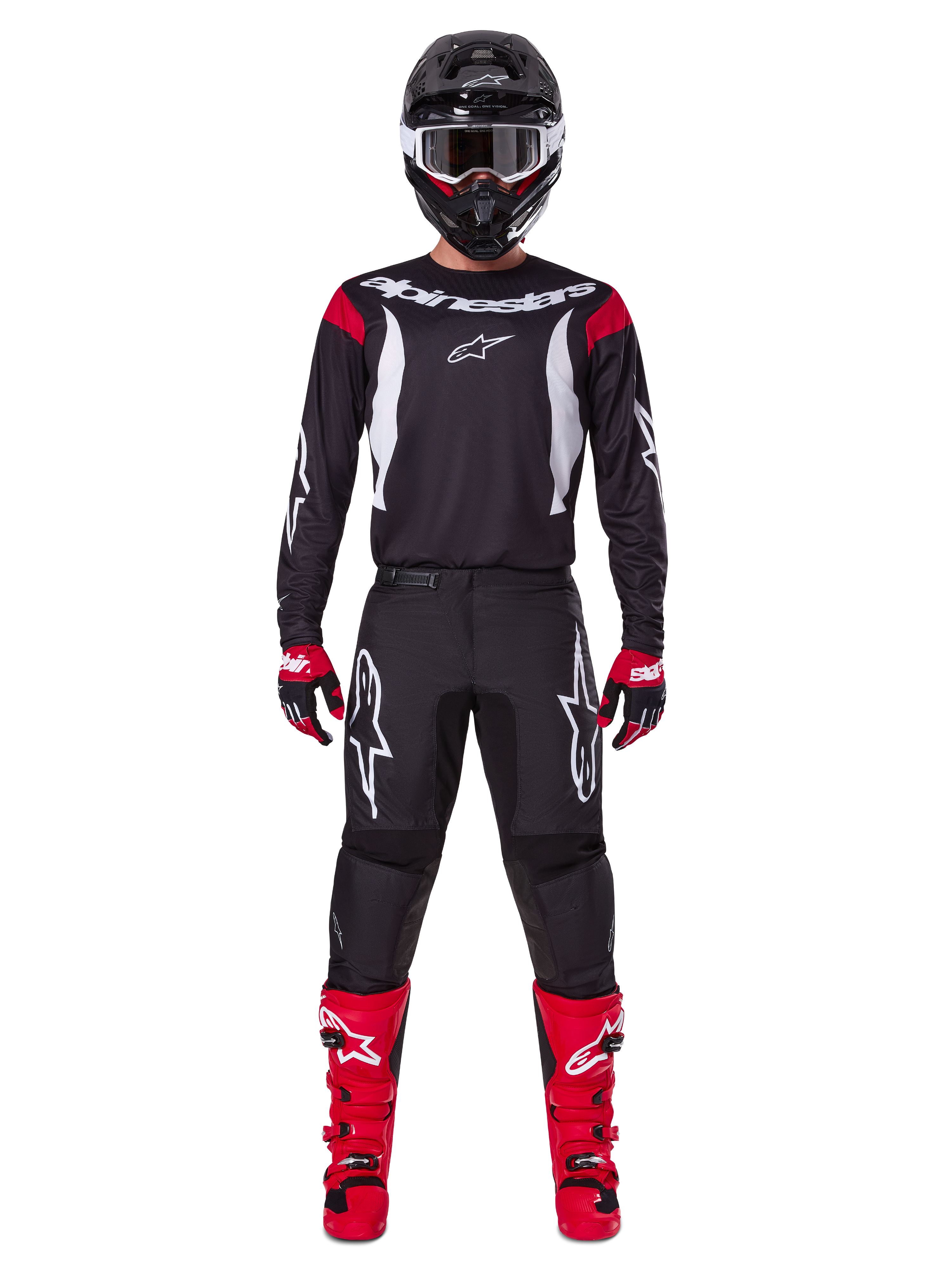 Alpinestars 2025 Fluid Haul Gear Set, zawodnik motocrossowy w pełnym stroju wyścigowym, czarna koszulka z czerwonymi akcentami na ramionach i białym logo, czarne spodnie z białym logo gwiazdy, jaskrawoczerwone buty, czerwono-czarne rękawice, czarny kask z białymi goglami, spójny wyczynowy styl off-road