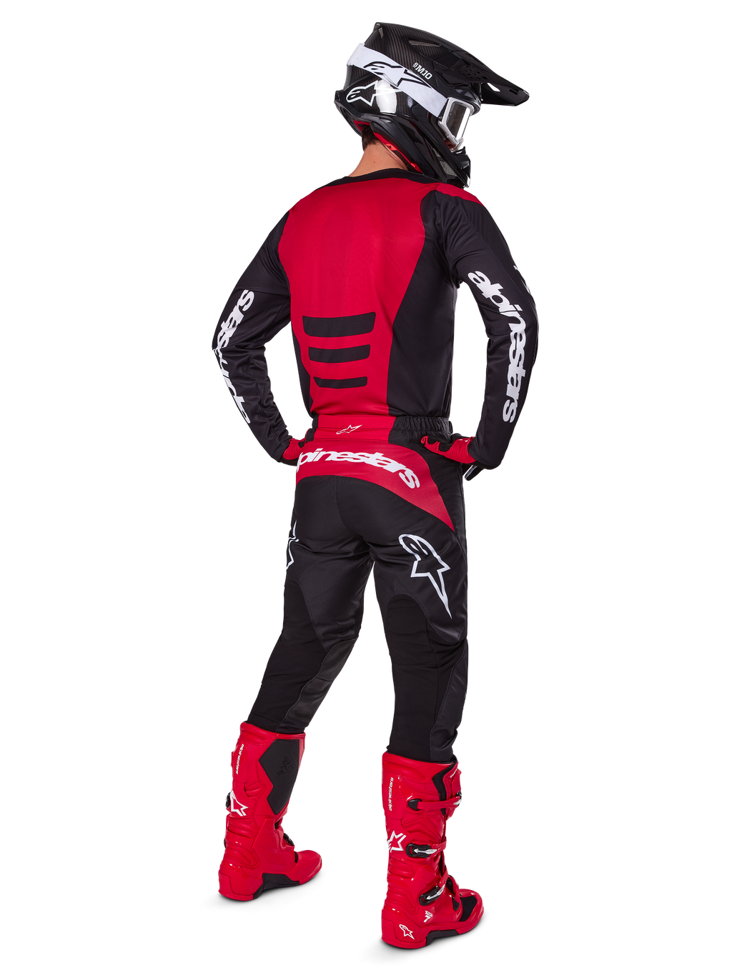 Zawodnik motocrossowy w zestawie Alpinestars 2025 Fluid Haul Gear Set, widok z tyłu, czerwono-czarna koszulka z białym brandingiem, pasujące czarne spodnie z czerwonymi akcentami, jaskrawoczerwone buty i czarny kask z białymi goglami, kompletny, dopasowany strój do wyścigów terenowych