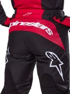 Alpinestars 2025 Fluid Haul Pants, spodnie motocrossowe, czarno-czerwone, widok z tyłu pokazujący wyraźne białe logo Alpinestars na czerwonym panelu siedziska, wytrzymała konstrukcja z poliestru z elastycznym pasem do jazdy off-road