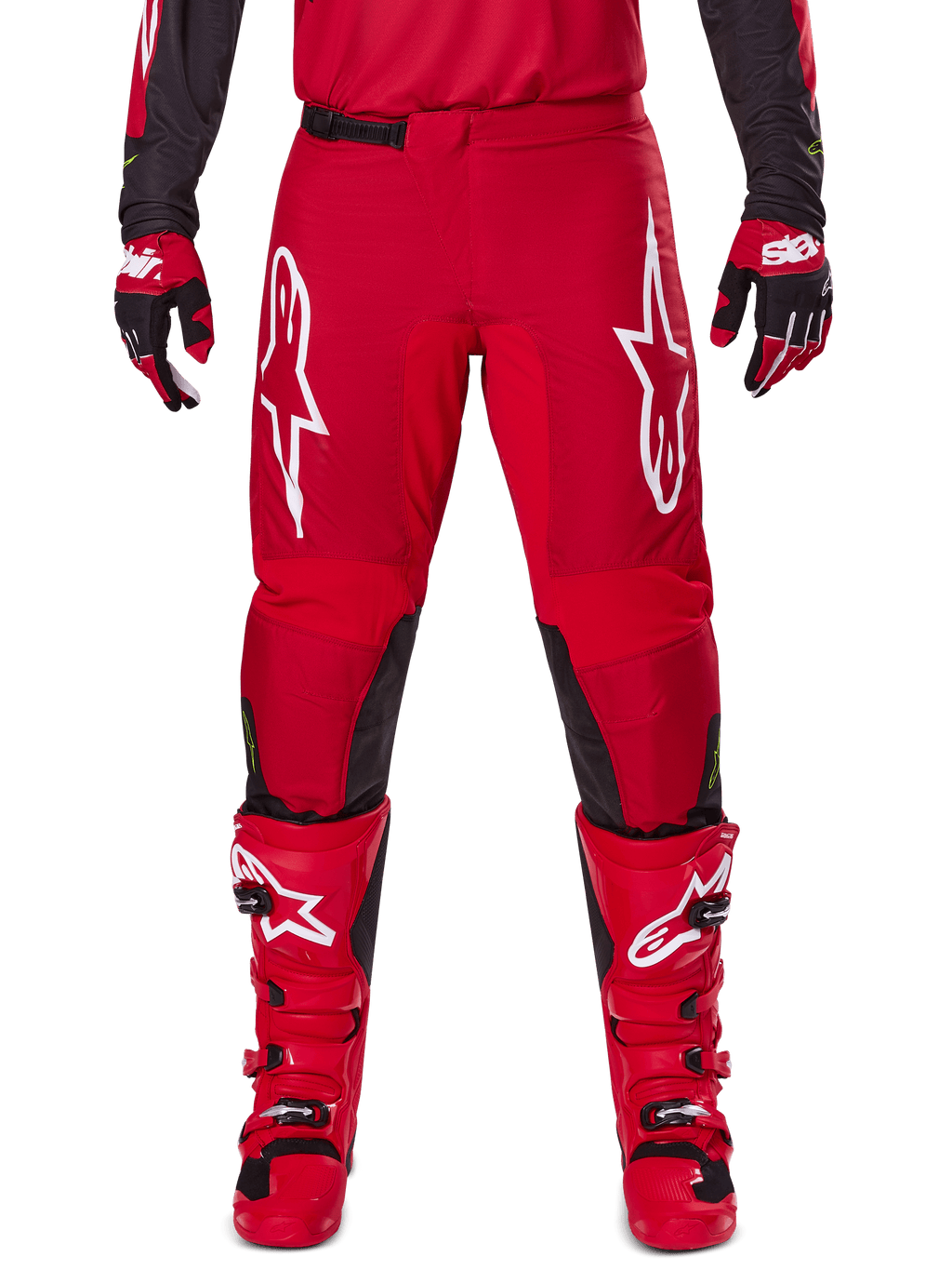 Alpinestars 2025 Fluid Haul Pants, spodnie motocrossowe, jaskrawoczerwone i czarne, z dużymi białymi logo na udach i czarnymi panelami po wewnętrznej stronie nogawek, noszone z pasującymi czerwonymi butami i rękawicami, sportowy krój zapewniający wydajność w motocrossie