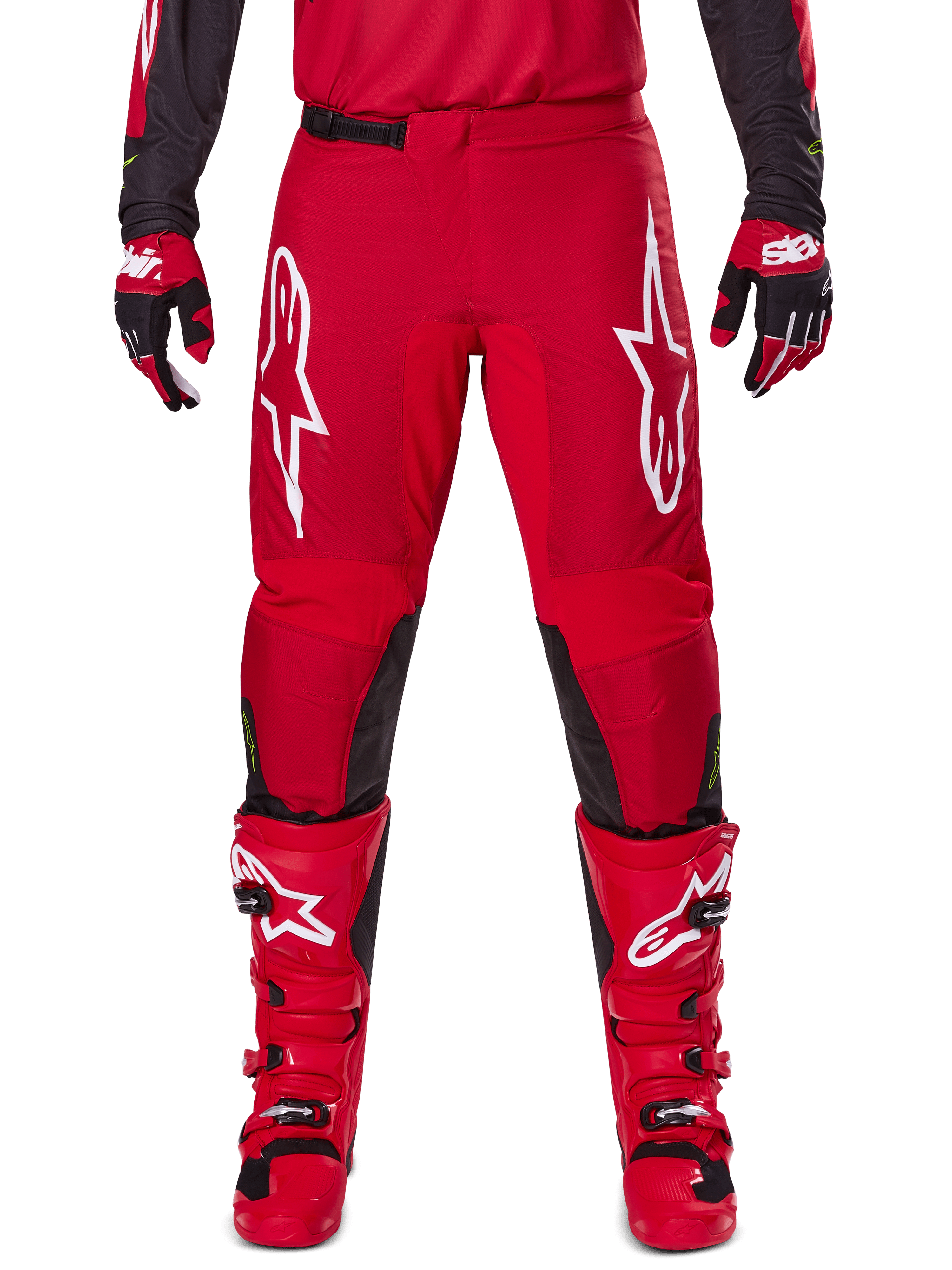 Alpinestars 2025 Fluid Haul Pants, spodnie motocrossowe, jaskrawoczerwone i czarne, z dużymi białymi logo na udach i czarnymi panelami po wewnętrznej stronie nogawek, noszone z pasującymi czerwonymi butami i rękawicami, sportowy krój zapewniający wydajność w motocrossie