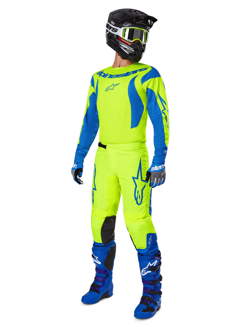 Alpinestars 2025 Fluid Haul Pants, spodnie motocrossowe, jaskrawożółty fluo i niebieski, noszone jako część pełnego zestawu wyścigowego z pasującą koszulką, niebieskimi butami i czarnym kaskiem, projekt o wysokiej widoczności do jazdy terenowej