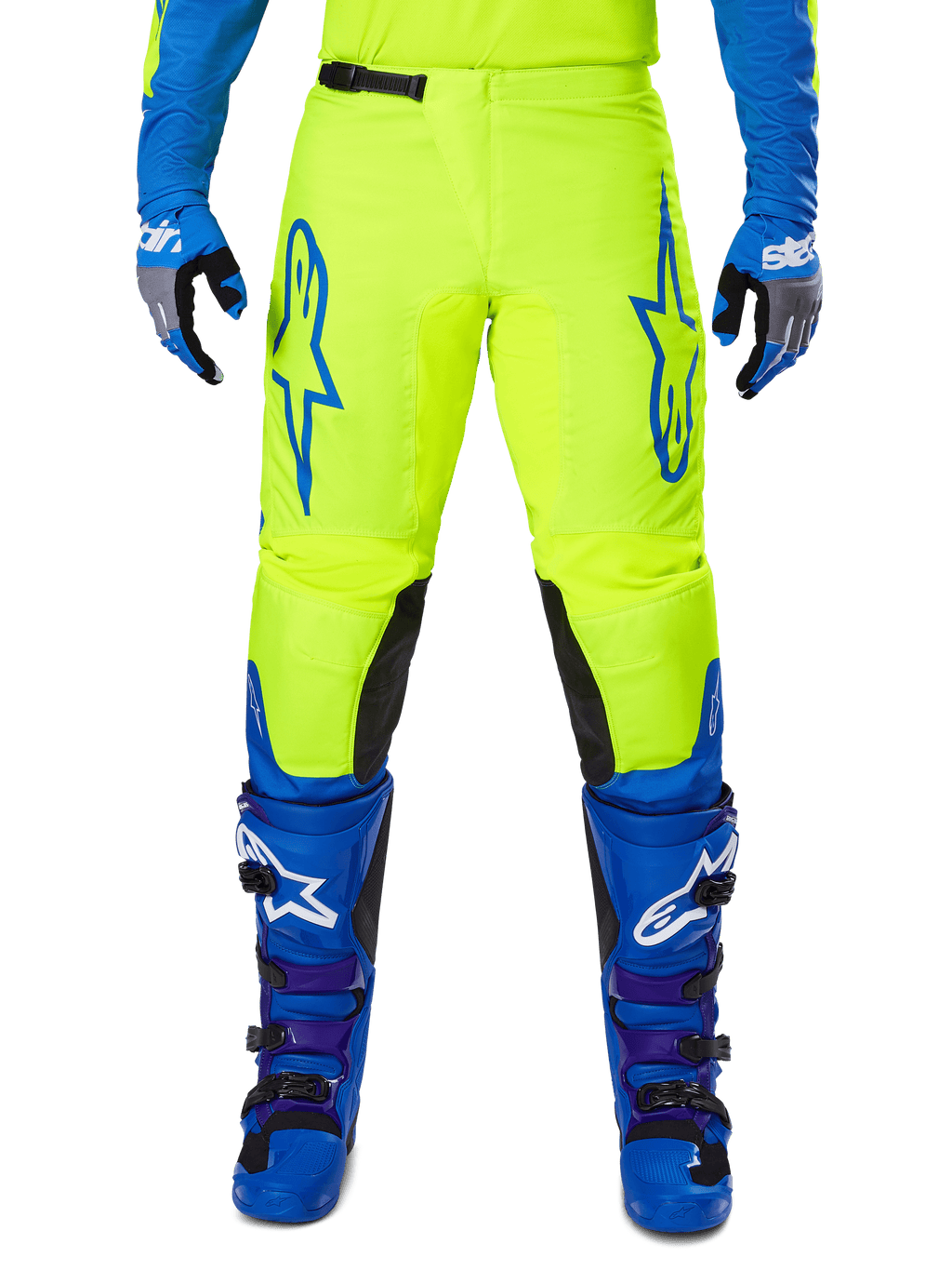Alpinestars 2025 Fluid Haul Pants, spodnie motocrossowe, jaskrawo żółte i niebieskie, noszone z pasującymi rękawicami i butami, czarne panele wewnętrzne na kolanach, wyrazisty niebieski branding na udach, sportowy ergonomiczny design.