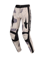 Alpinestars 2026 Racer Lahnd Pants, spodnie motocrossowe, Sand Camo, baza w odcieniu złamanej bieli z szarymi i czarnymi wzorami pociągnięć pędzla, czarne grafiki gwiazd na udach, wzmocnione czarne panele na kolanach, regulowana klamra w pasie, ergonomiczny design wyścigowy off-road