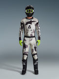 Alpinestars 2026 Racer Lahnd Gear Set, kompletny zestaw motocrossowy, wzór Sand Camo w odcieniach bieli, szarości i czerni, czarny kask z jaskrawozielonymi goglami, neonowe zielone rękawice i czarne buty z białym logo, profesjonalny strój do jazdy off-road