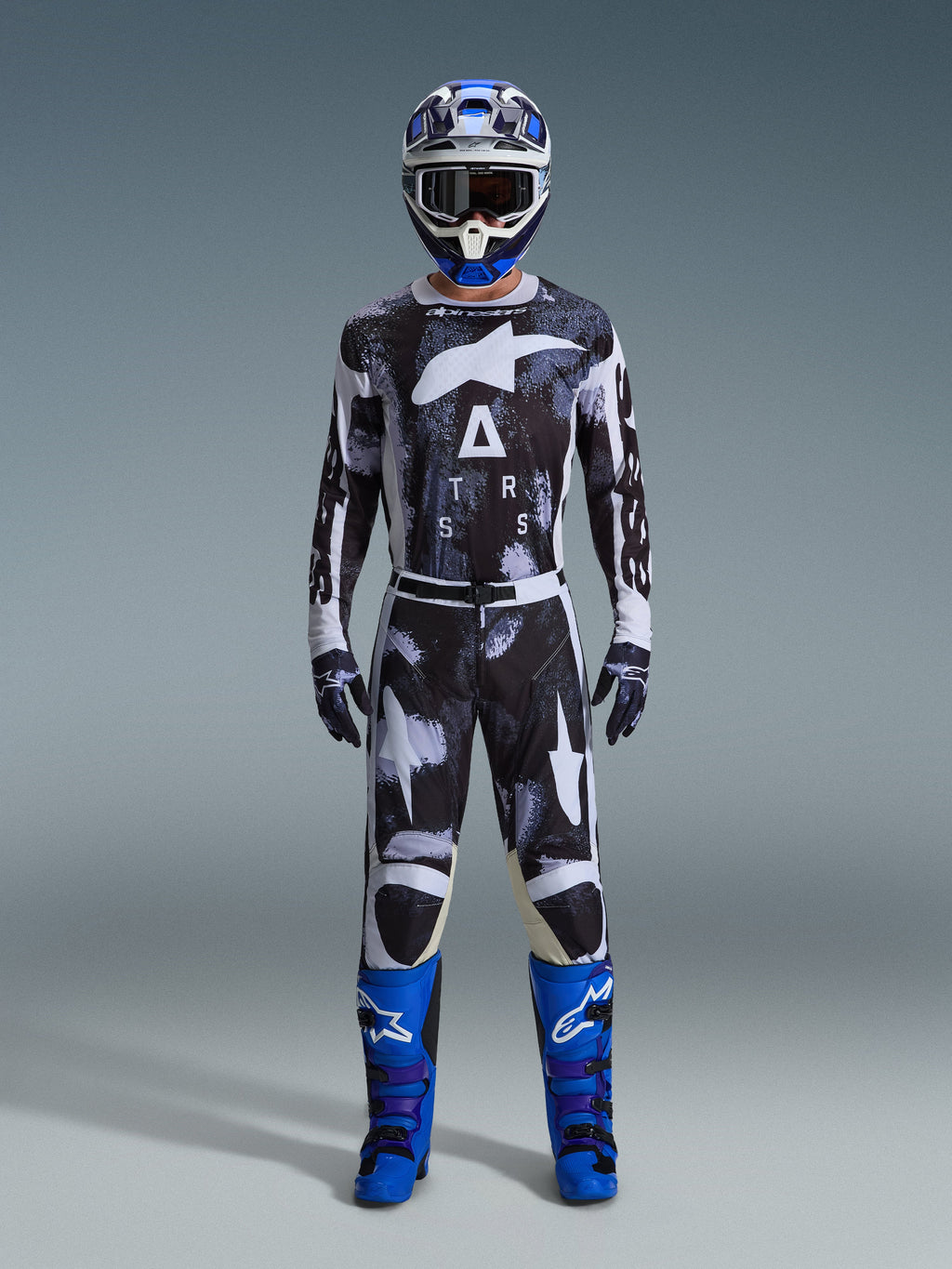 Alpinestars 2026 Racer Lahnd Gear Set, strój motocrossowy, czarno-biały z abstrakcyjnym wzorem Iron Camo, zestawiony z niebiesko-białym kaskiem i jaskrawoniebieskimi butami, kompletny zestaw wyścigowy do jazdy off-road