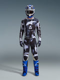 Alpinestars 2026 Racer Lahnd Gear Set, strój motocrossowy, czarno-biały z abstrakcyjnym wzorem Iron Camo, zestawiony z niebiesko-białym kaskiem i jaskrawoniebieskimi butami, kompletny zestaw wyścigowy do jazdy off-road