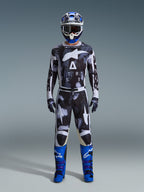 Alpinestars 2026 Racer Lahnd Gear Set, strój motocrossowy, czarno-biały z abstrakcyjnym wzorem Iron Camo, zestawiony z niebiesko-białym kaskiem i jaskrawoniebieskimi butami, kompletny zestaw wyścigowy do jazdy off-road