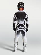 Alpinestars Techstar Swan, męskie spodnie i koszulka motocrossowa, czarne i białe, sportowy krój wyścigowy, widok z tyłu.