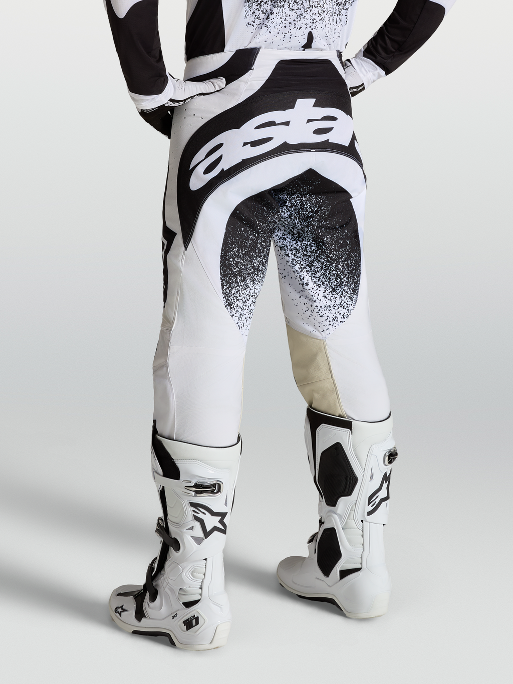 Alpinestars Techstar Swan, profesjonalne spodnie motocrossowe, czarno-białe z brandingiem Astar, widok z tyłu