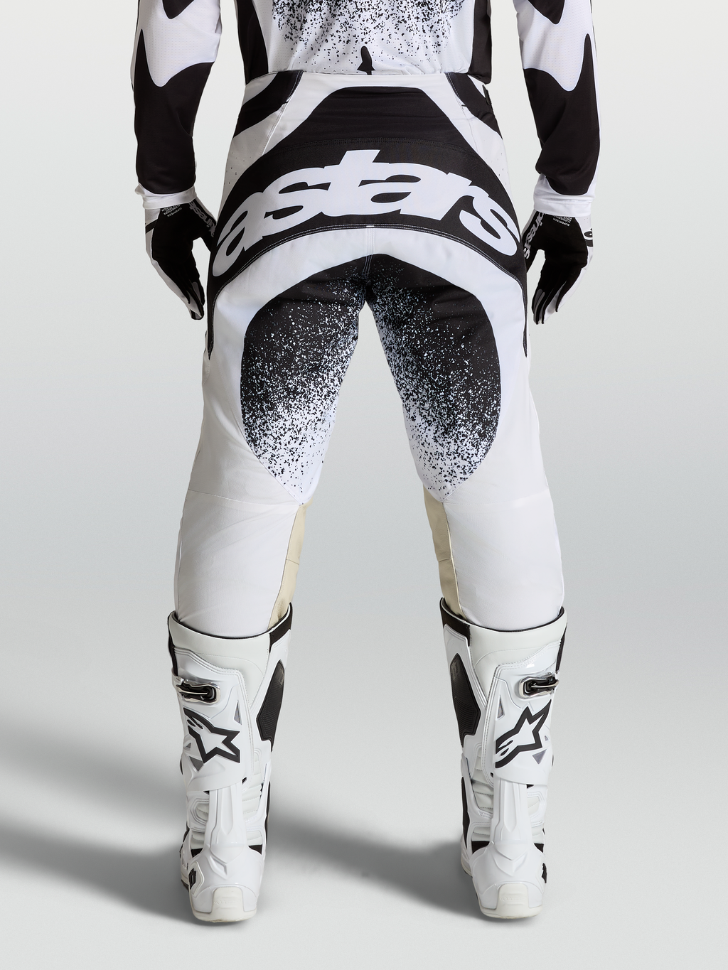 Alpinestars Techstar Swan, męskie spodnie motocrossowe, czarno-białe, widok z tyłu na grafikę Astars i konstrukcję Babel
