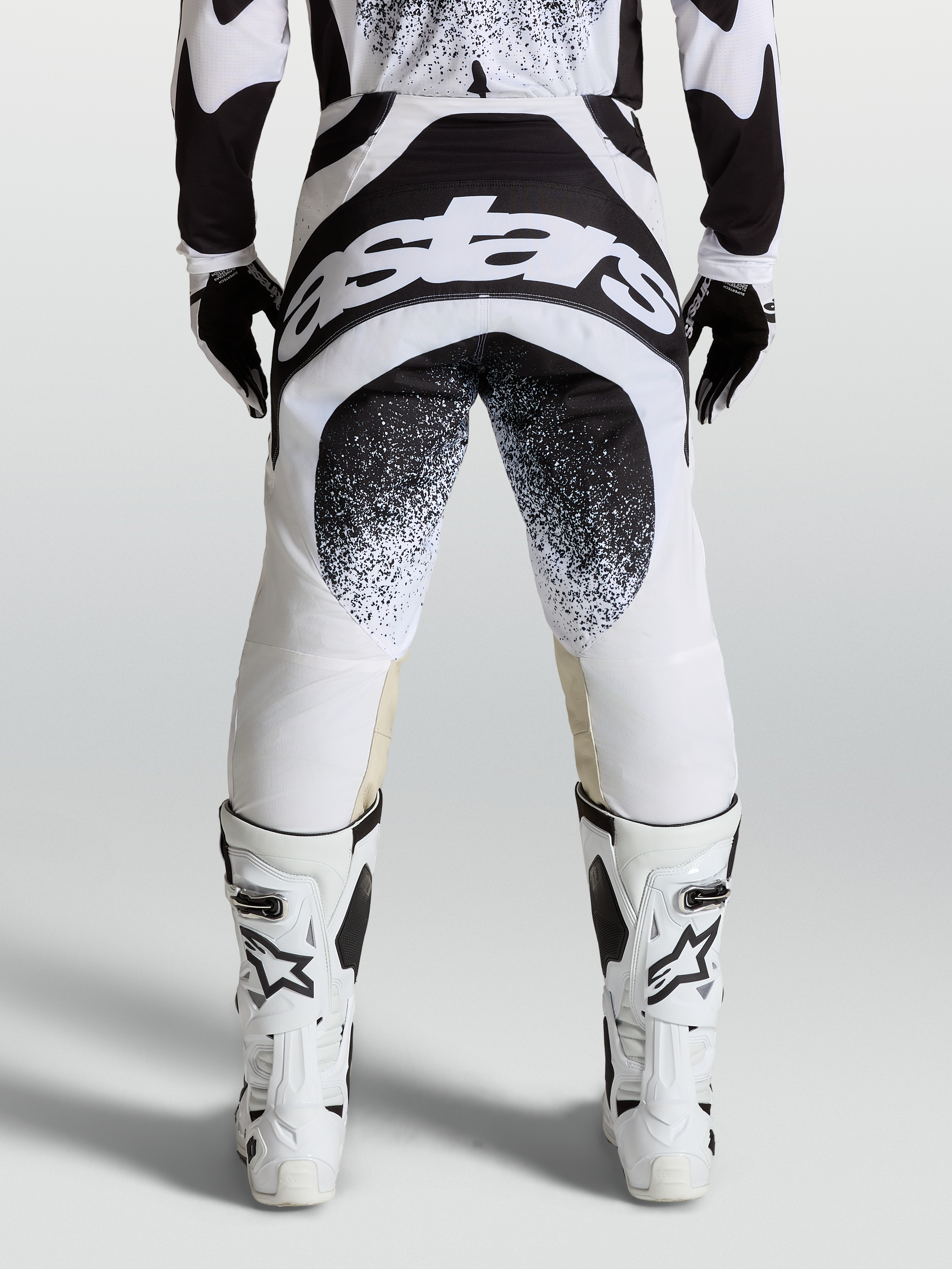 Alpinestars Techstar Swan, męskie spodnie motocrossowe, czarno-białe, widok z tyłu na grafikę Astars i konstrukcję Babel