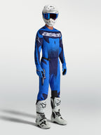 Alpinestars Techstar Swan, męskie spodnie motocrossowe, niebieskie i granatowe, z pasującą koszulką i białymi butami.