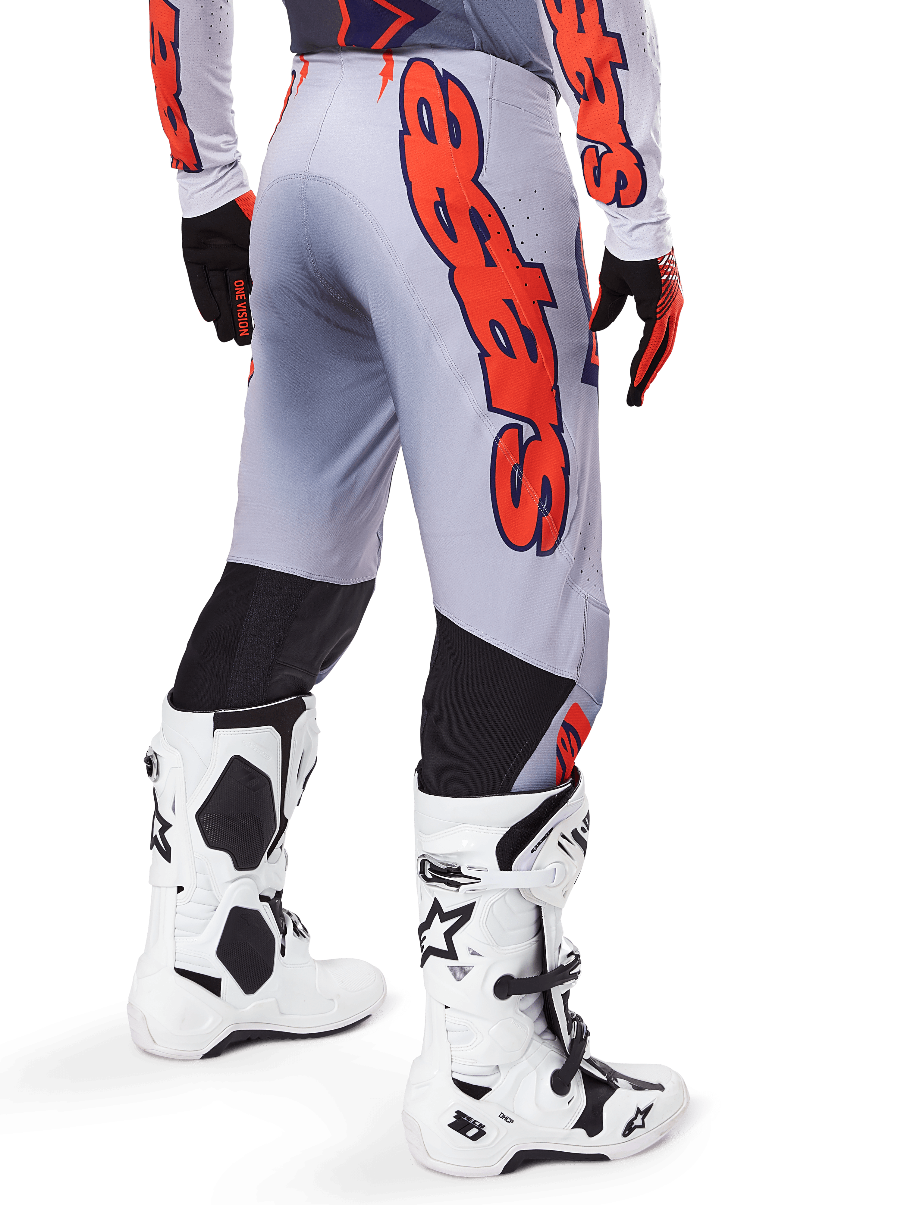 Spodnie Alpinestars Supertech Lipan 2025, spodnie motocrossowe, szare i pomarańczowe fluo, widok z tyłu z dużą pomarańczową grafiką Alpinestars, czarne elastyczne panele, zestaw z pasującą koszulką i białymi butami, profesjonalna odzież wyścigowa