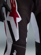 Alpinestars 2026 Supertech AFD Vista Pants, spodnie motocrossowe, czarno-czerwono-białe, zbliżenie na okolicę uda z dużym czerwono-białym logo gwiazdy, laserowo wycinane perforacje zapewniające przepływ powietrza, wytrzymała elastyczna tkanina ripstop