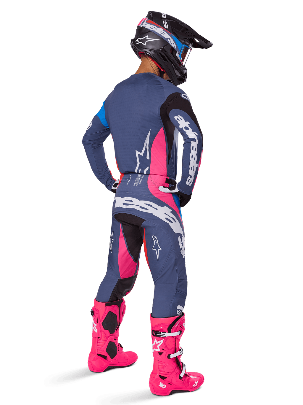 Motocyklista motocrossowy od tyłu w spodniach Alpinestars 2025 Techstar Dreem, szaro-niebieski i jaskraworóżowy design z czarnymi akcentami, dopasowana koszulka i intensywnie różowe buty, sportowy krój wyścigowy do off-roadu