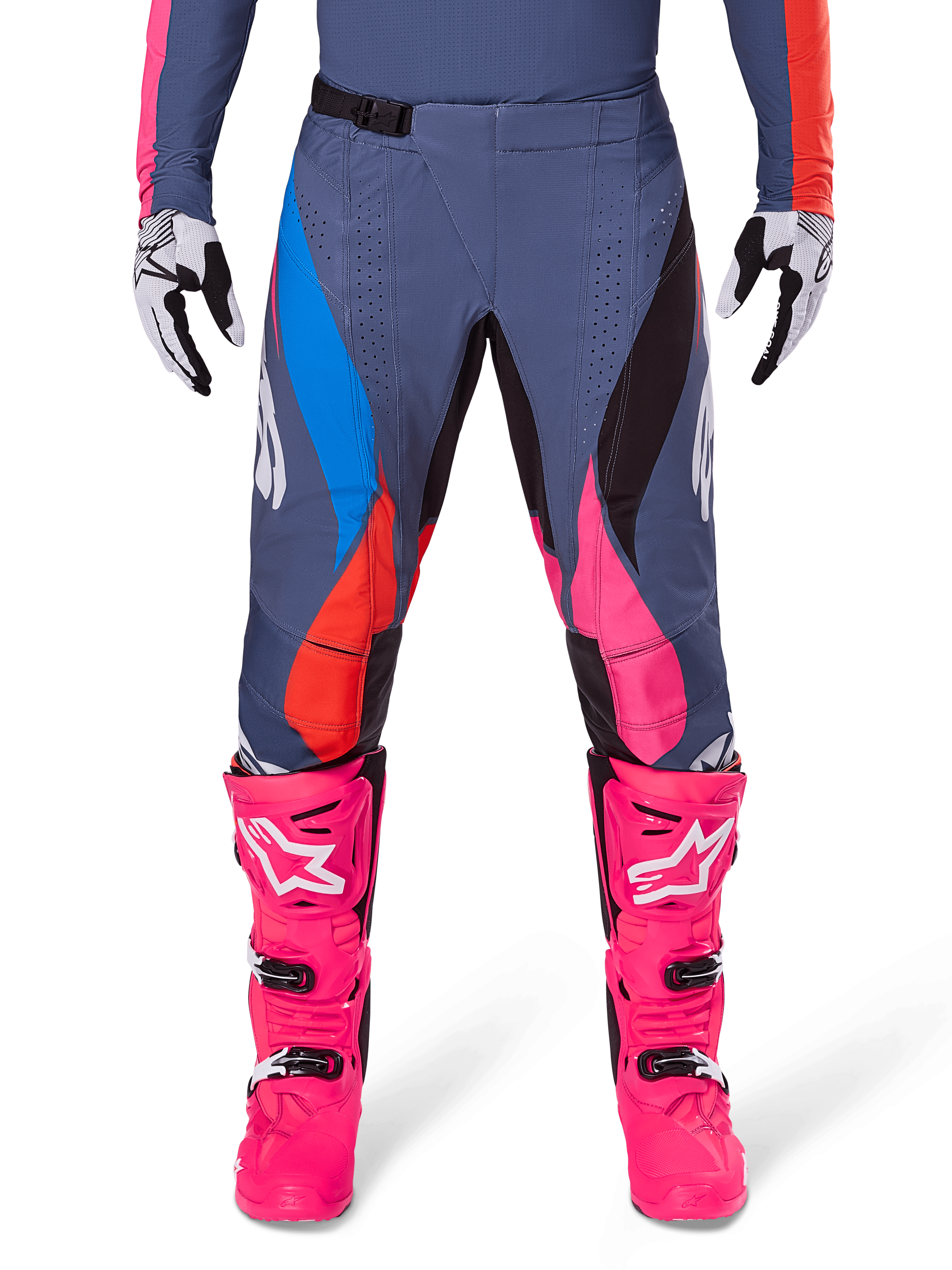 Alpinestars Techstar Dreem Pants 2025, spodnie motocrossowe, szare wielokolorowe z niebieskimi, różowymi i pomarańczowymi akcentami, zestawione z jaskraworóżowymi butami i biało-czarnymi rękawicami, laserowo wycinane perforacje na udach, magnetyczna klamra w pasie, sportowy krój wyścigowy do rywalizacji off-road