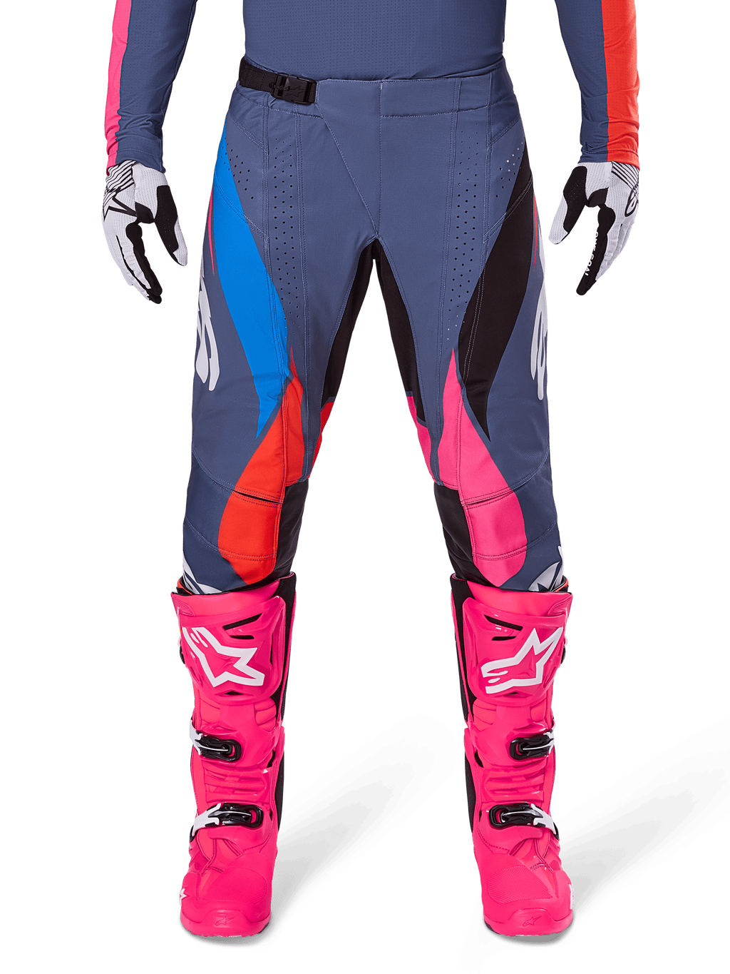Alpinestars 2025 Techstar Dreem Pants, spodnie motocrossowe, szary wielokolorowy z różowymi, niebieskimi i pomarańczowymi akcentami, noszone z jaskraworóżowymi butami motocrossowymi i pasującą koszulką, sportowy krój wyścigowy z laserowo wycinanymi otworami wentylacyjnymi