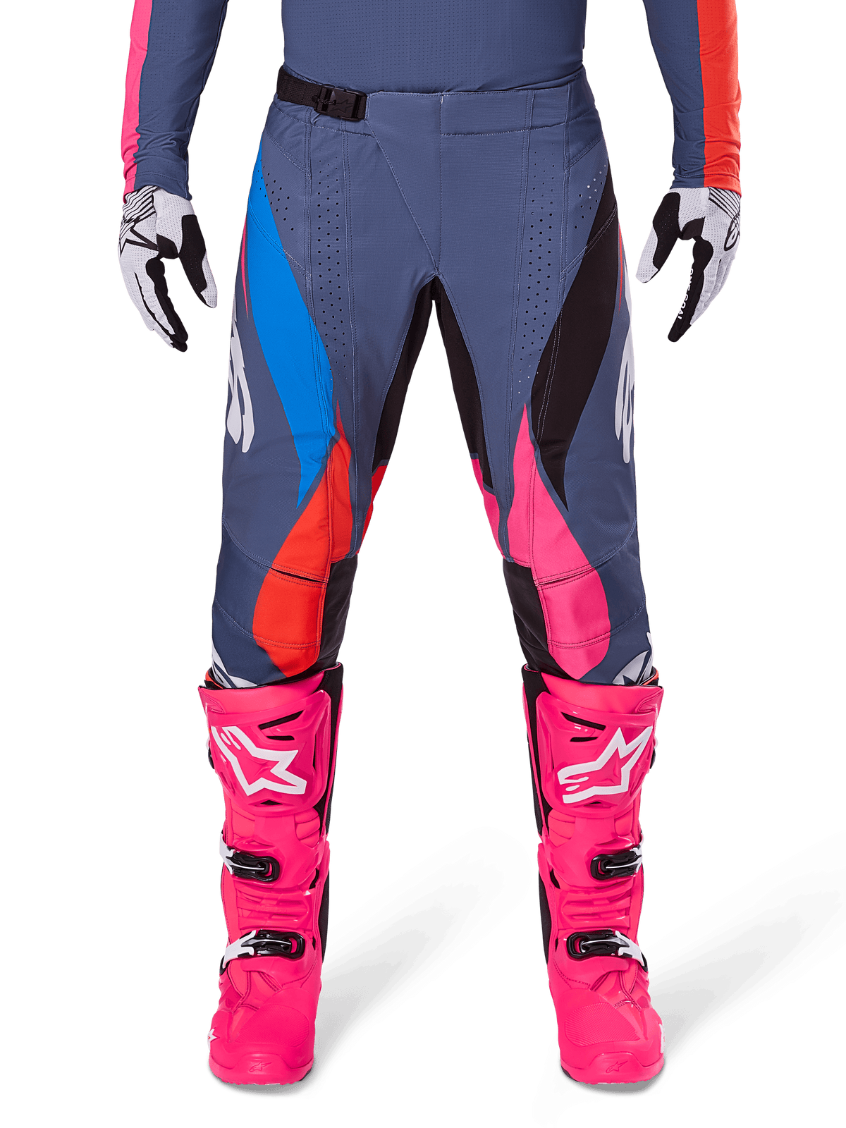 Alpinestars 2025 Techstar Dreem Pants, spodnie motocrossowe, szary wielokolorowy z różowymi, niebieskimi i pomarańczowymi akcentami, noszone z jaskraworóżowymi butami motocrossowymi i pasującą koszulką, sportowy krój wyścigowy z laserowo wycinanymi otworami wentylacyjnymi