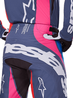 Alpinestars Techstar Dreem Pants 2025, spodnie motocrossowe, szary multikolor z różowymi i białymi akcentami, widok z tyłu z dużym brandingiem Alpinestars na siedzeniu i tekstem specyfikacji technicznej w pasie, noszone jako skoordynowany zestaw wyścigowy