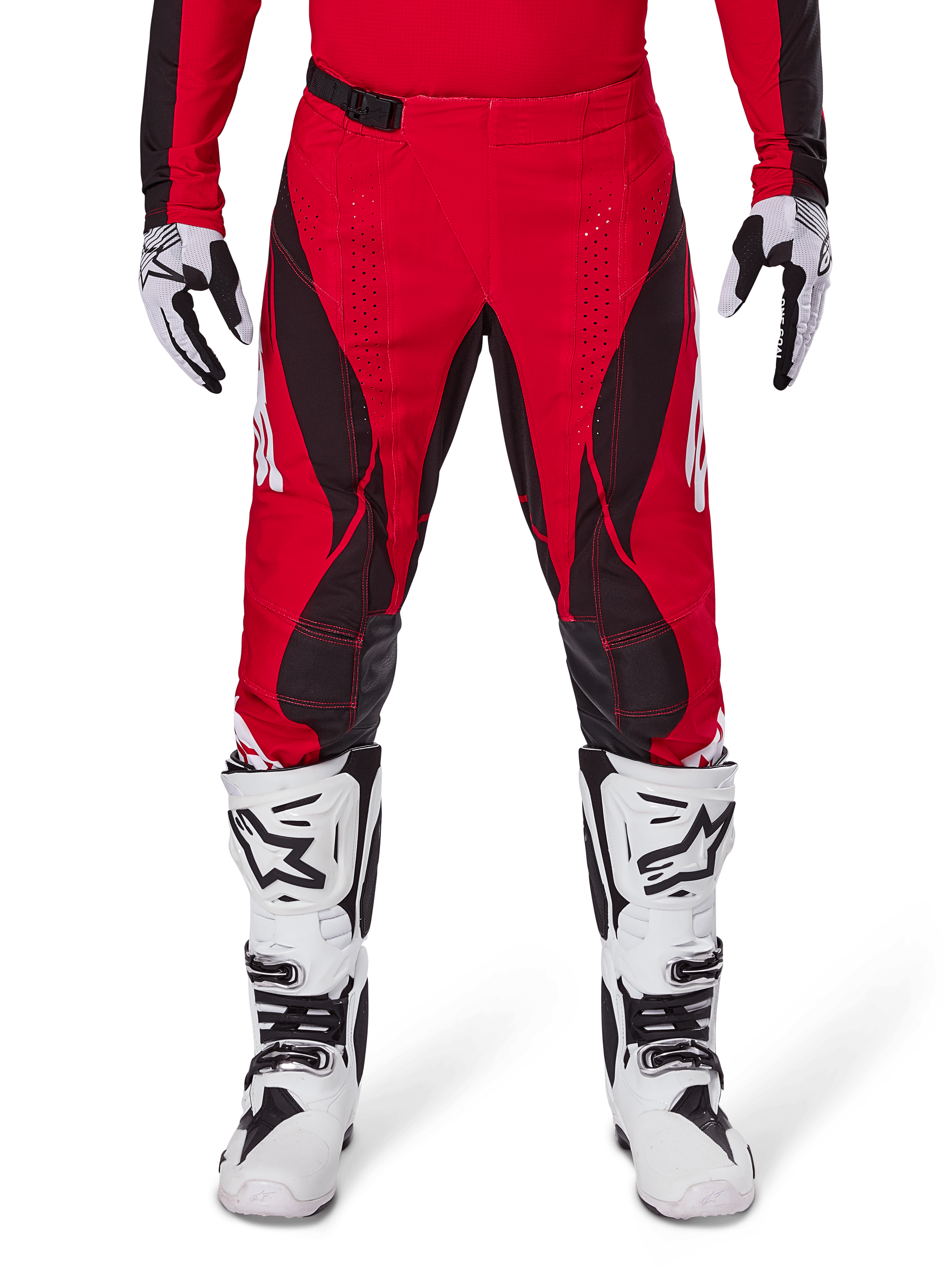 Alpinestars Techstar Dreem Pants 2025, spodnie motocrossowe, jaskrawoczerwone i czarne, z kanciastymi wzorami i laserowo wycinanymi otworami wentylacyjnymi, noszone z białymi butami motocrossowymi i pasującymi rękawicami do wyścigów terenowych