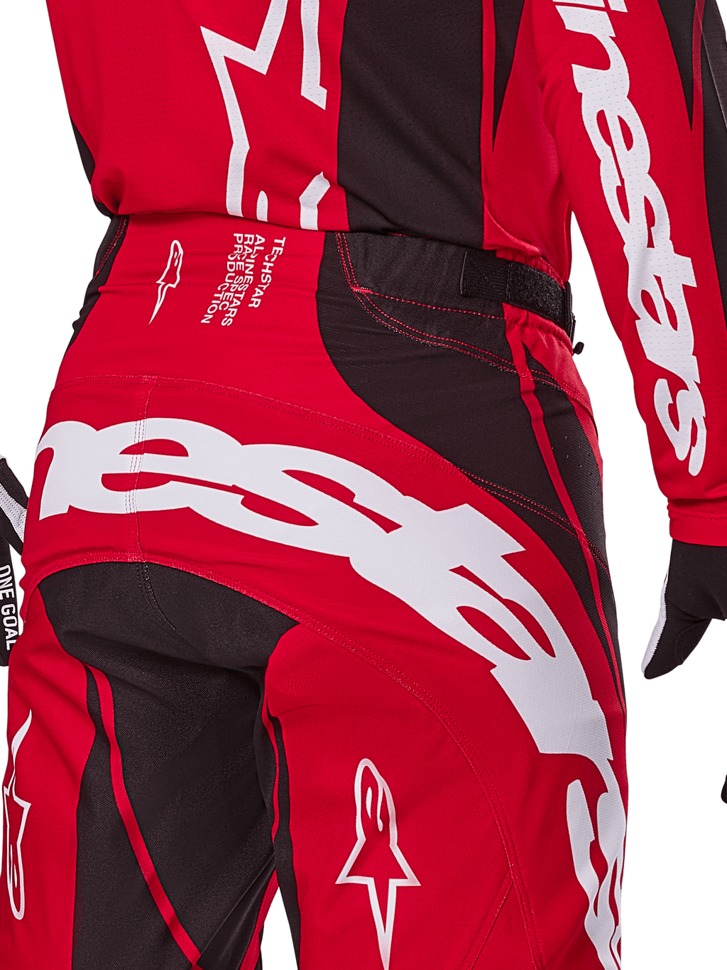 Alpinestars Techstar Dreem Pants 2025, spodnie motocrossowe, jaskrawoczerwone i czarne, zbliżenie na tylną część pasa i siedzenia, wyraźny biały branding Alpinestars, czarne elastyczne panele, techniczny tekst na pasku, zaprojektowane pod kątem wydajności w wyścigach terenowych.