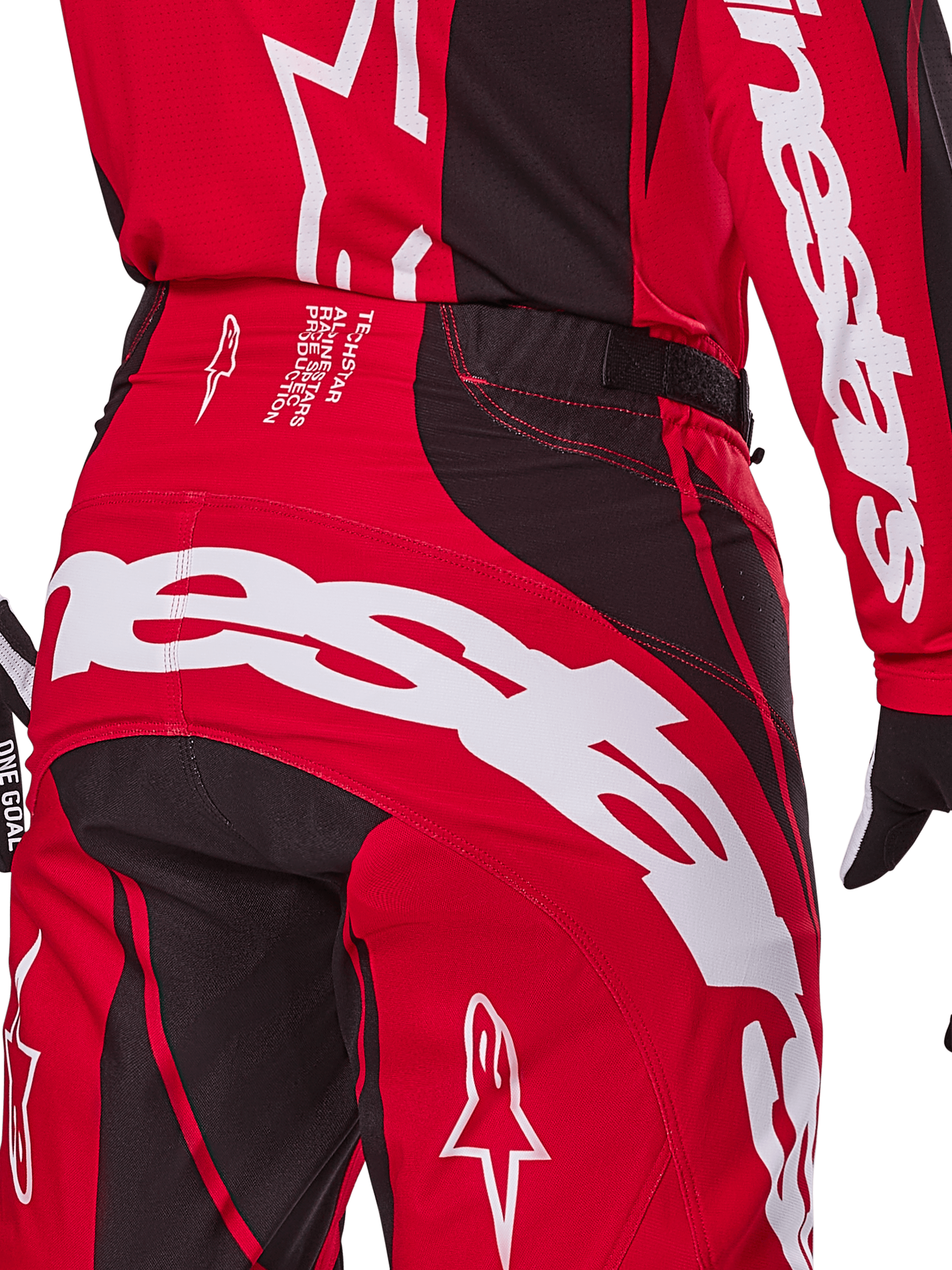 Alpinestars Techstar Dreem Pants 2025, spodnie motocrossowe, jaskrawoczerwone i czarne, zbliżenie na tylną część pasa i siedzenia, wyraźny biały branding Alpinestars, czarne elastyczne panele, techniczny tekst na pasku, zaprojektowane pod kątem wydajności w wyścigach terenowych.