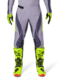Alpinestars Techstar Dreem Pants 2025, spodnie motocrossowe, jasnoszare i ciemnoszare z neonowymi żółtymi akcentami, zestawione z neonowymi żółtymi butami i rękawicami, laserowo wycinana wentylacja, czarne klamry, czerwone podeszwy butów, profesjonalny sprzęt motocrossowy