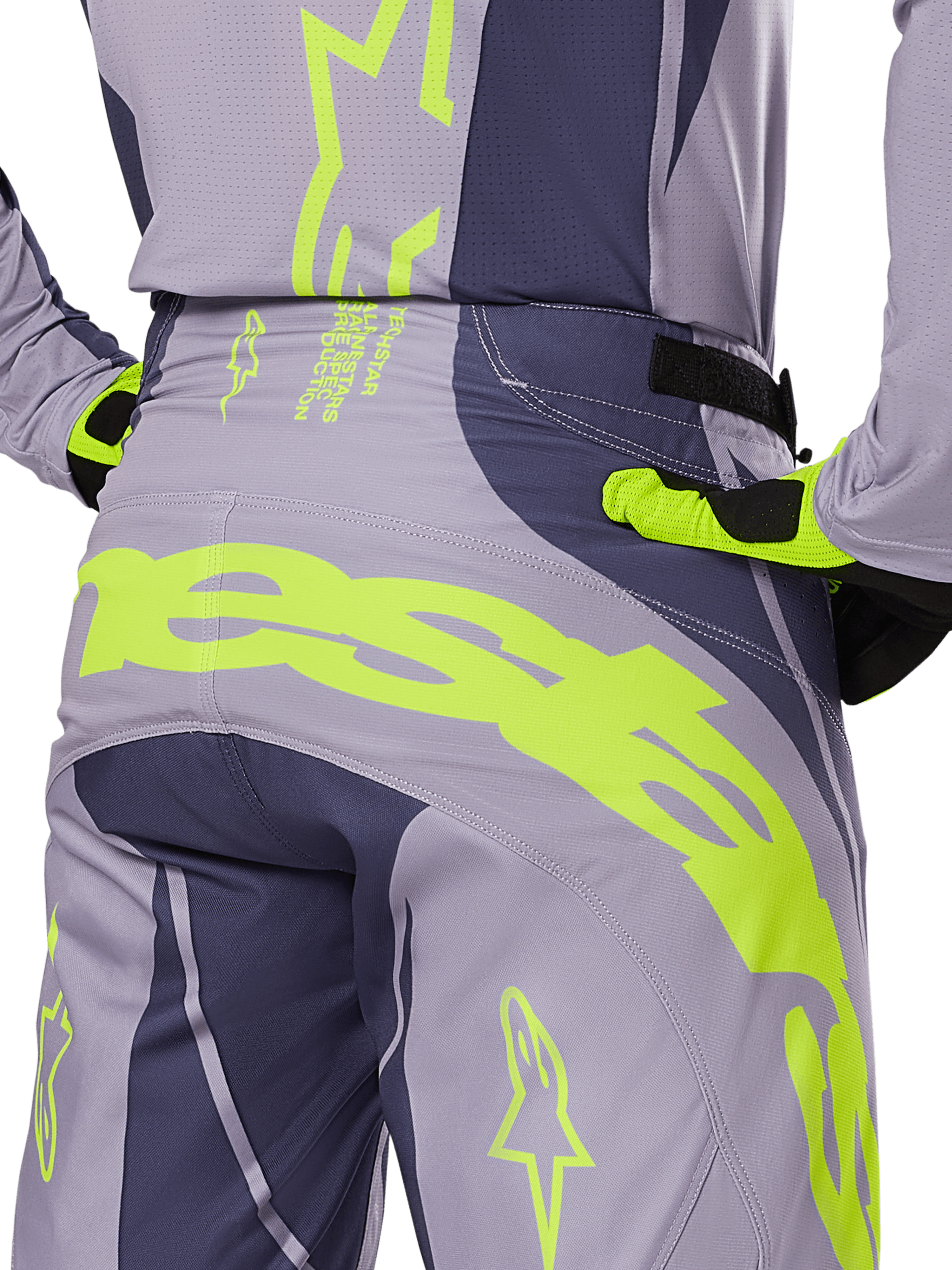Alpinestars Techstar Dreem Pants 2025, spodnie motocrossowe, szare i ciemnoszare z jaskrawymi limonkowymi akcentami, widok z tyłu na detale z pasującą koszulką i rękawicami, duże fluorescencyjne żółte logo na siedzeniu, sportowy krój wyścigowy do jazdy off-road