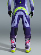 Alpinestars 2026 Supertech Scenz Pants, spodnie motocrossowe, fioletowe i neonowożółte (fluo), widok z tyłu pokazujący duże żółte logo na siedzeniu, w zestawie z pasującą bluzą, rękawicami i butami ochronnymi, sportowy krój do profesjonalnych wyścigów motocrossowych