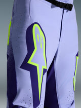 Alpinestars 2026 Supertech Scenz Pants, spodnie motocrossowe, fioletowo-żółty fluo, zbliżenie na duże żółte logo na udzie, laserowo wycinane perforacje wentylacyjne i magnetyczna klamra w pasie, sportowy krój off-road