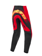 Alpinestars Supertech Scenz Pants 2026, spodnie motocrossowe, czerwono-czarno-żółte, widok z tyłu z dużym żółtym logo na siedzeniu, czerwone panele z grafikami czarnych gwiazd, laserowo wycinane perforacje w pasie oraz czarne wzmocnione panele w dolnej części nogawek.