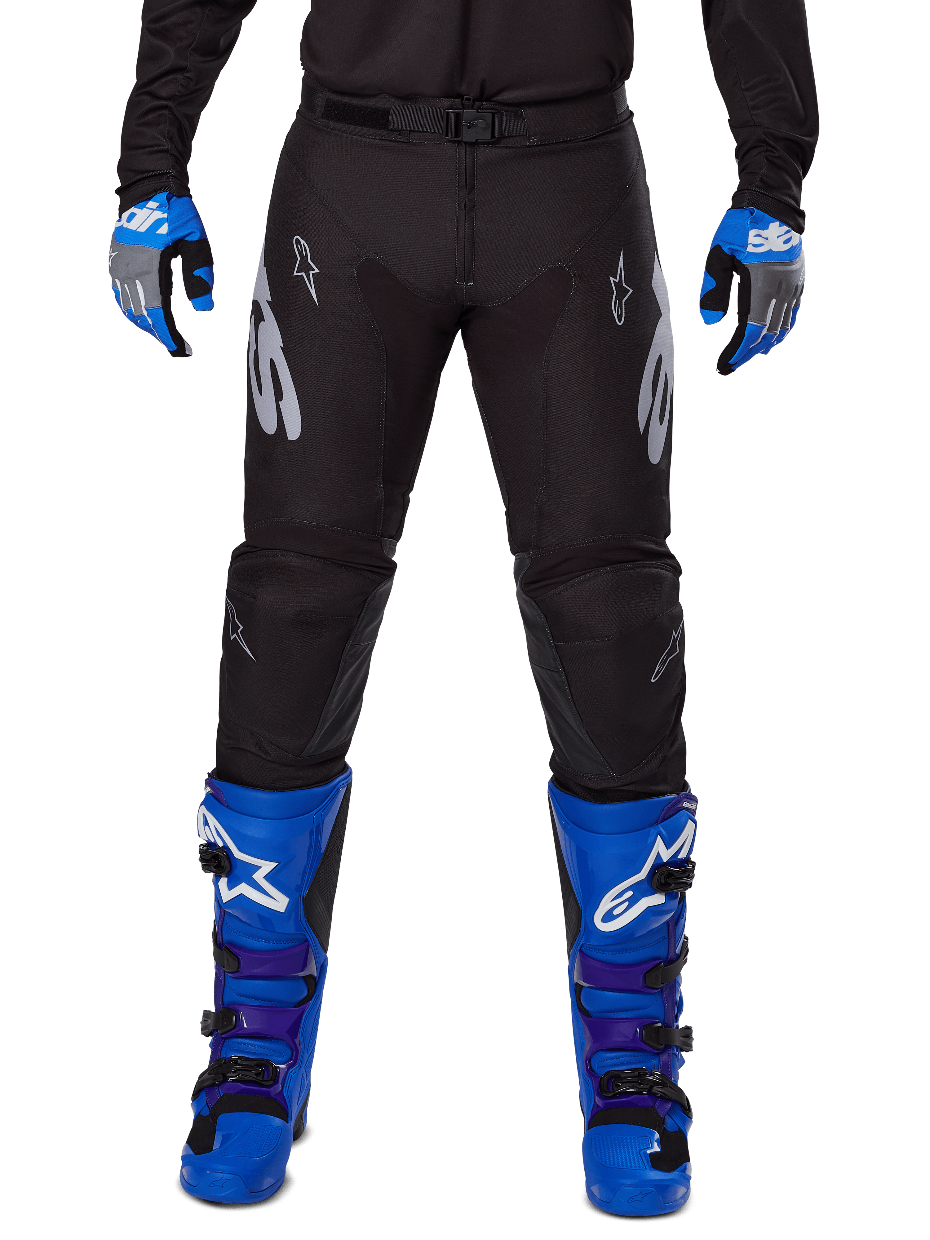 Alpinestars 2025 Racer Graphite Pants, spodnie motocrossowe, czarno-szare, noszone z niebiesko-szarymi rękawicami i niebieskimi butami, srebrny branding Astars na udach i wzmocnione kolana, sportowy design do jazdy w terenie
