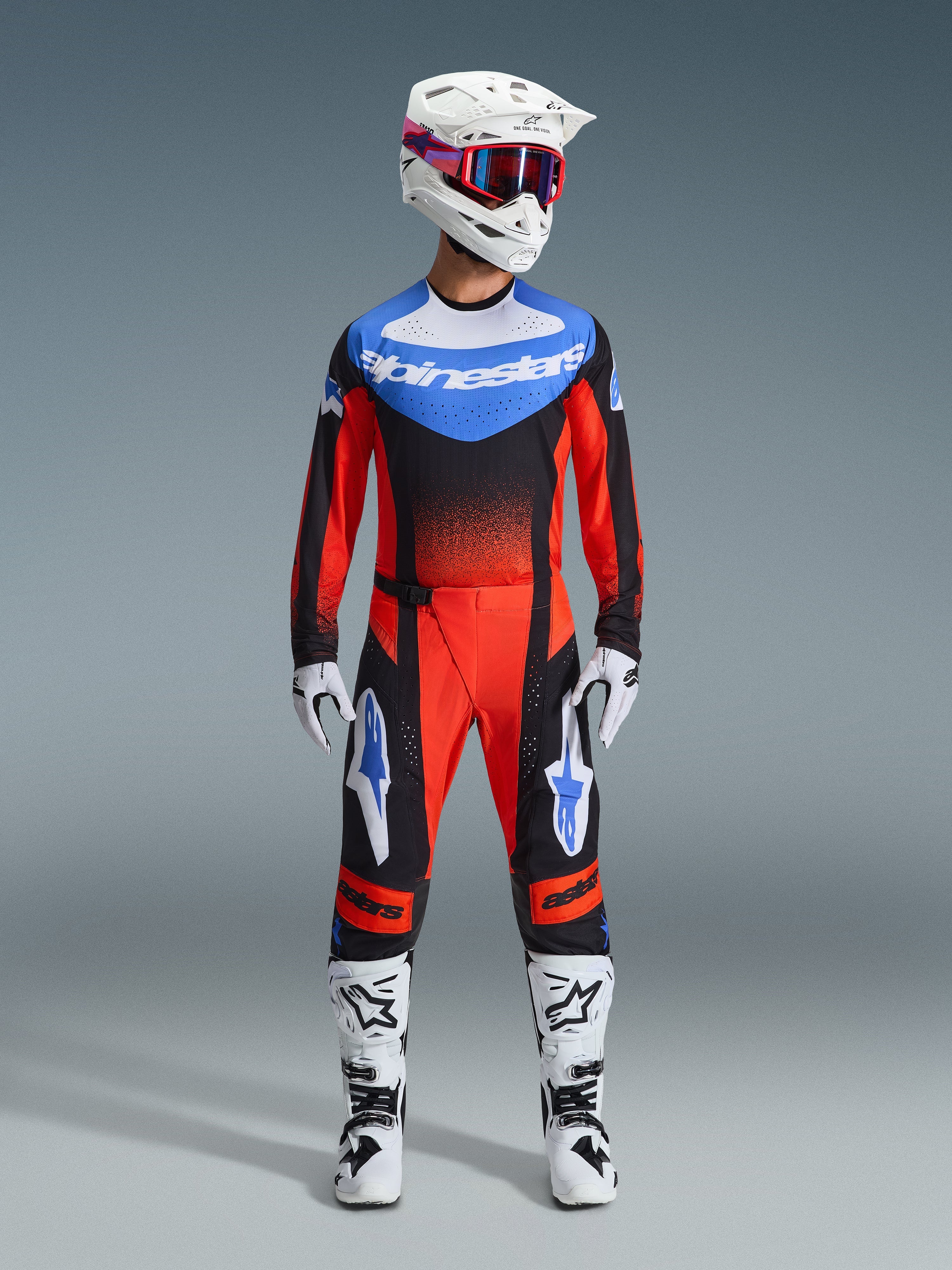 Alpinestars 2026 Techstar Knif Gear Set, odzież motocrossowa, czerwony i czarny z niebieskimi akcentami, kompletny strój MX zawierający koszulkę, spodnie, biały kask z różową i niebieską grafiką, białe rękawice i białe buty, profesjonalny sprzęt do wyścigów terenowych