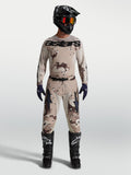 Alpinestars Racer Lone Gear Set, męski zestaw motocrossowy w piaskowym kamuflażu, na modelu z czarnym kaskiem i butami.